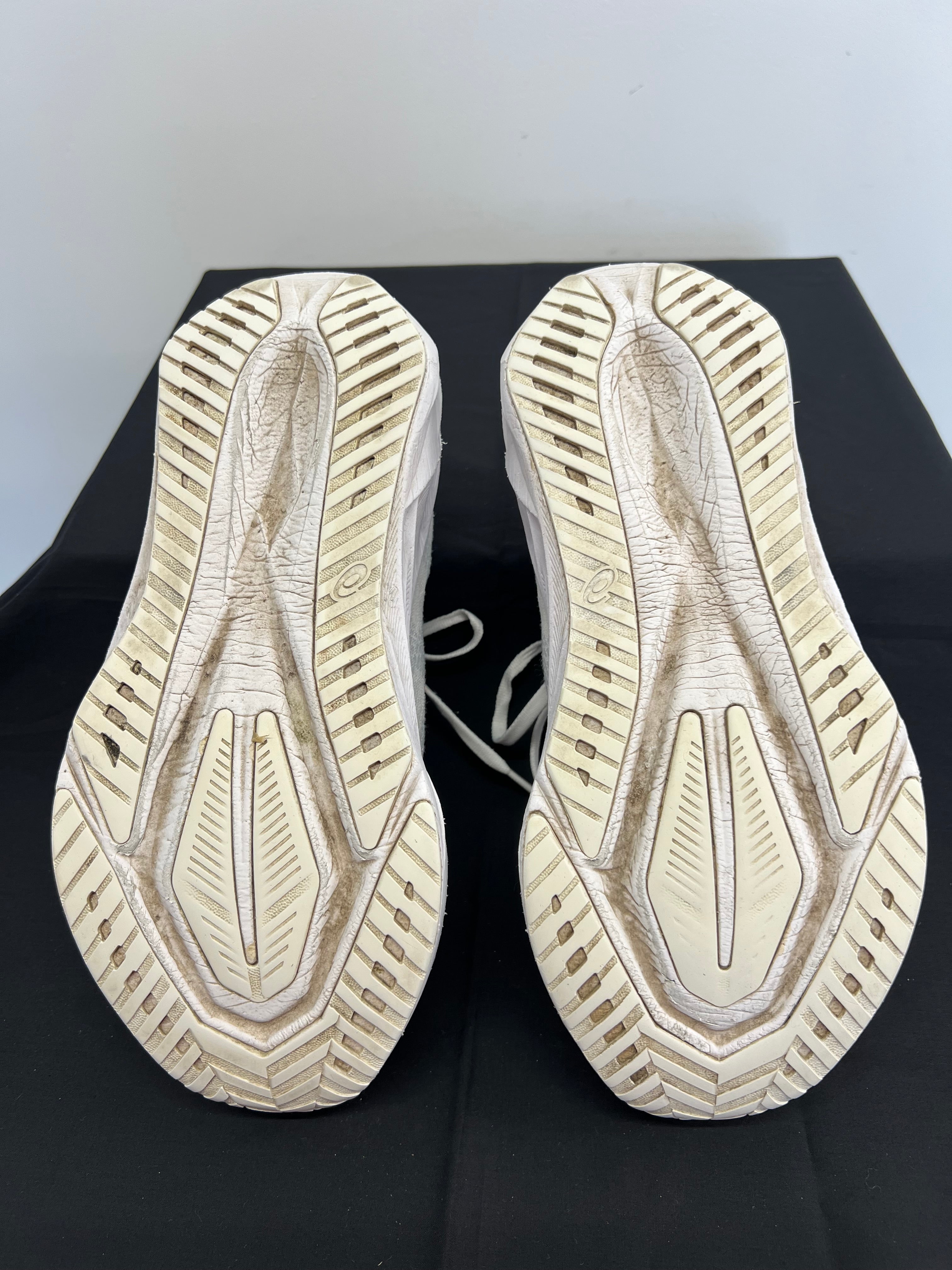 Outsole view of white Asics Novablast 5 trainers showing tread pattern and wear
