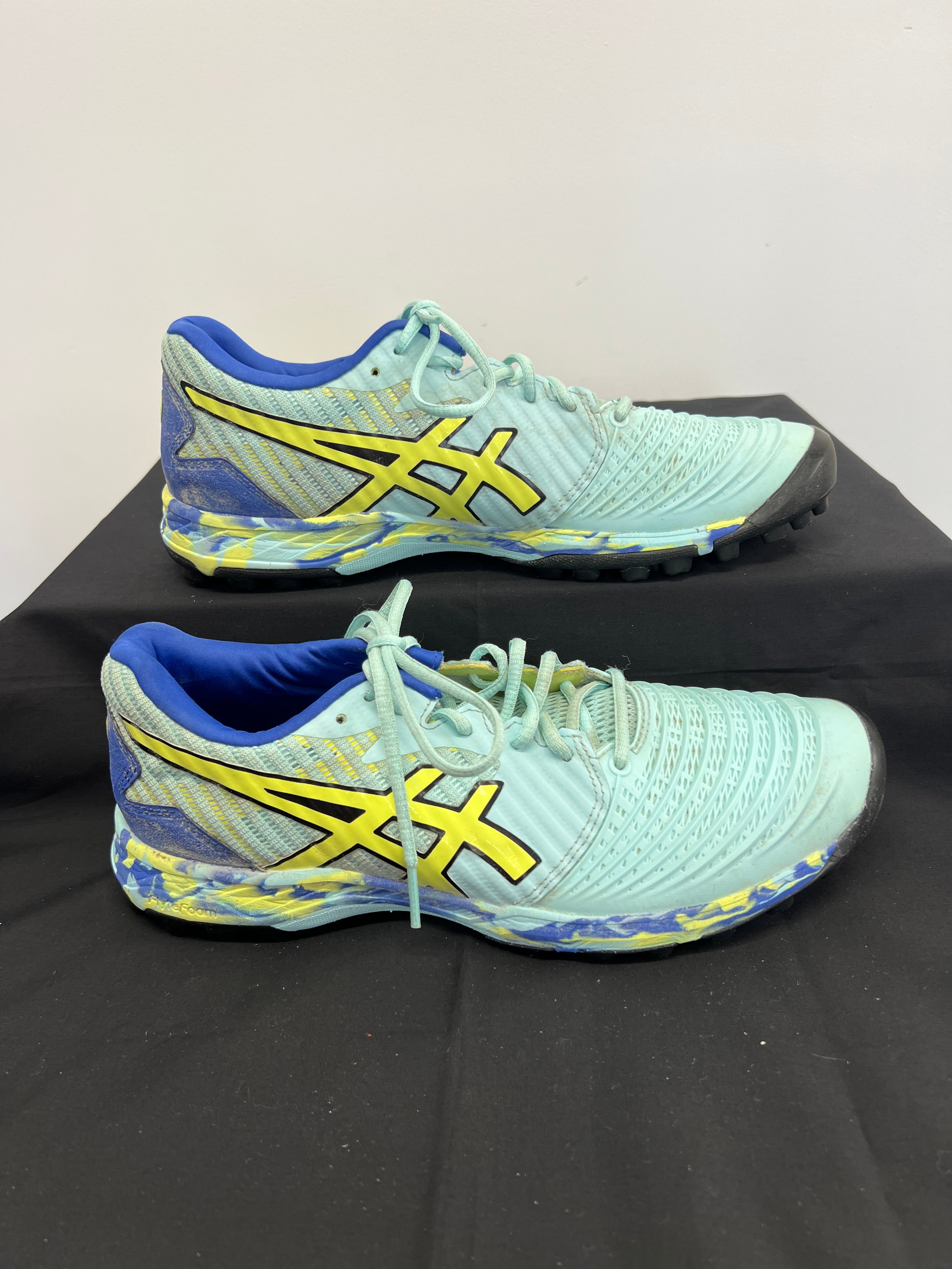 Side profile of Asics FlyteFoam turf shoes showing blue and yellow patterned sole