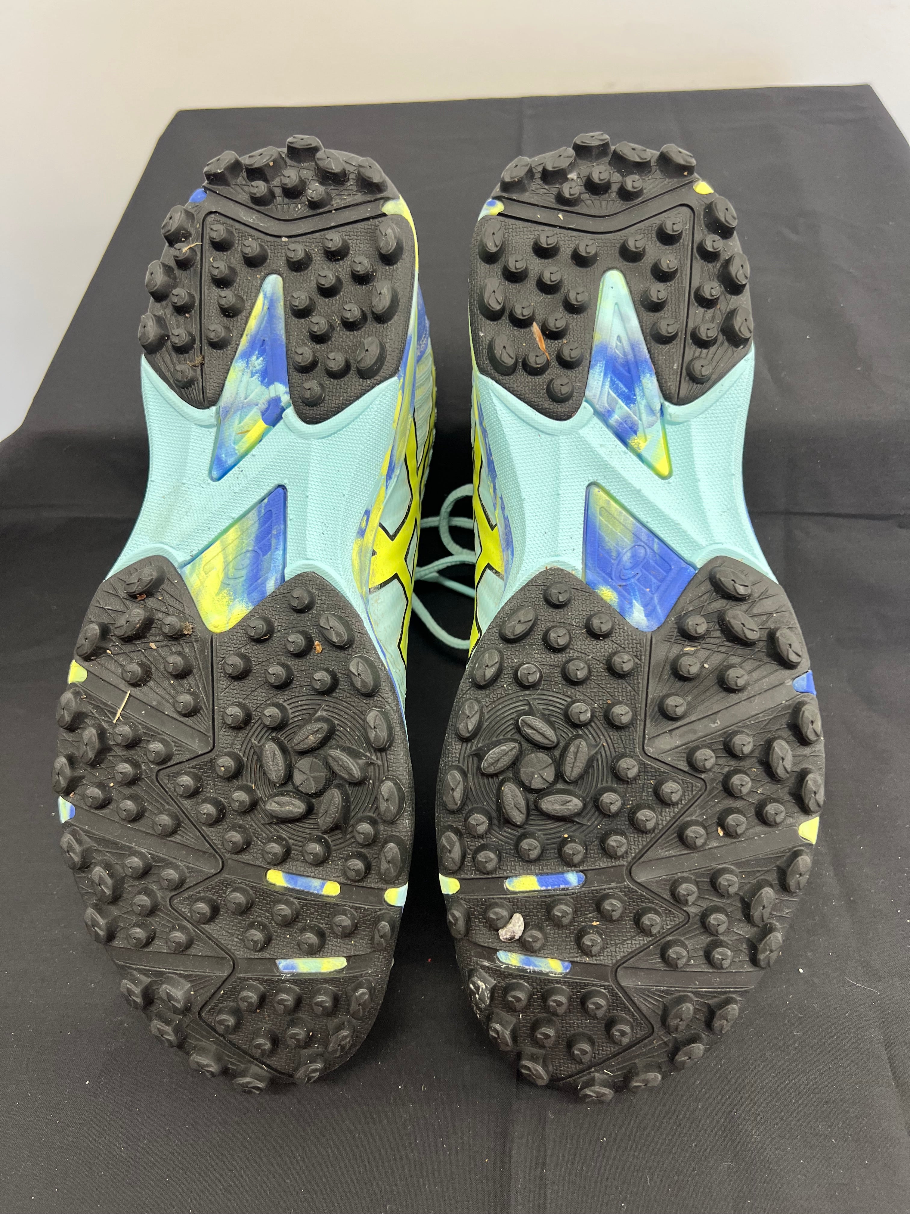 Bottom view highlighting studded rubber outsole for turf grip