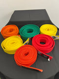 Set of six rolled martial arts belts in orange, green, yellow, and red on black surface
