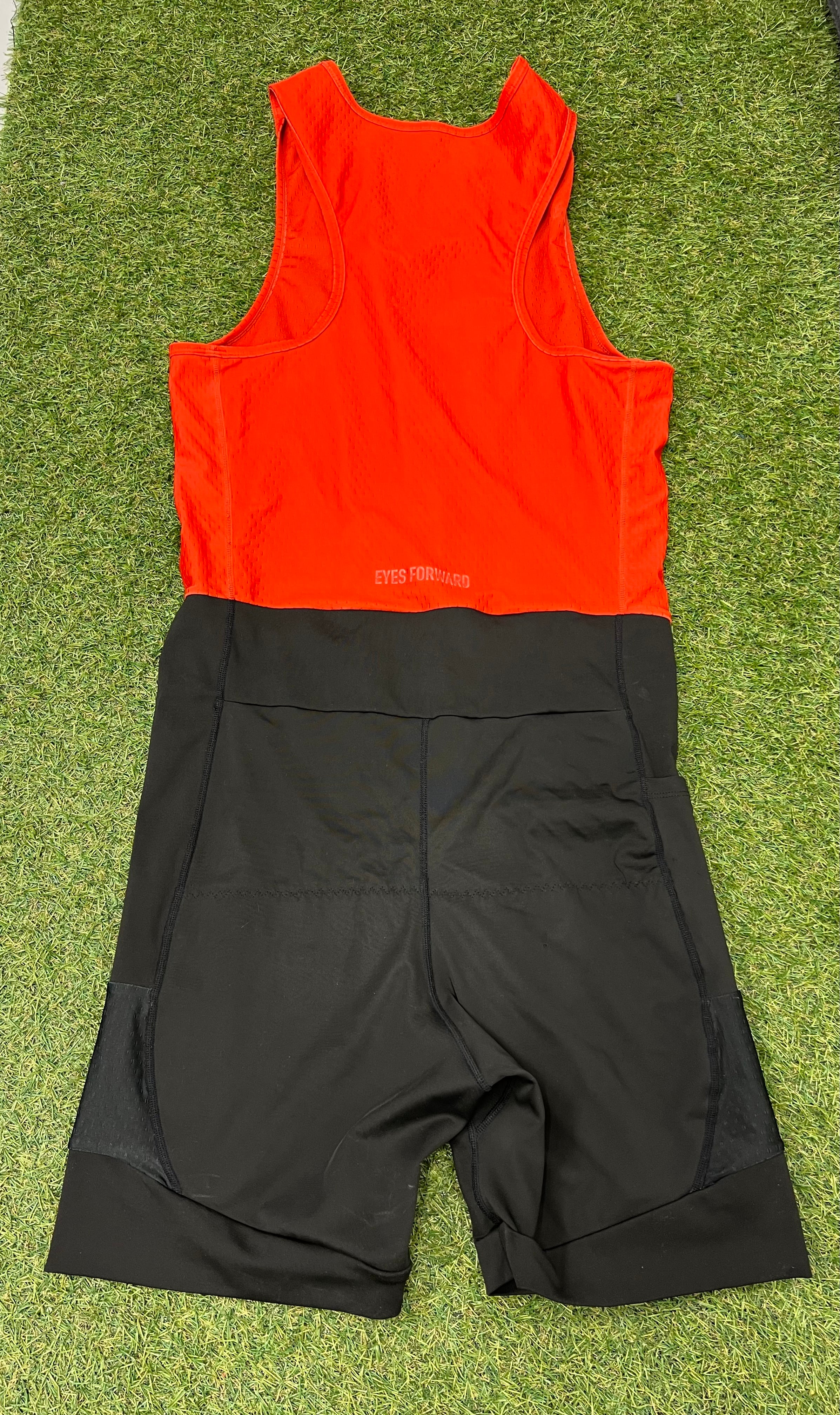 Back view of rowing suit showing red mesh upper back and black lower section with side pockets