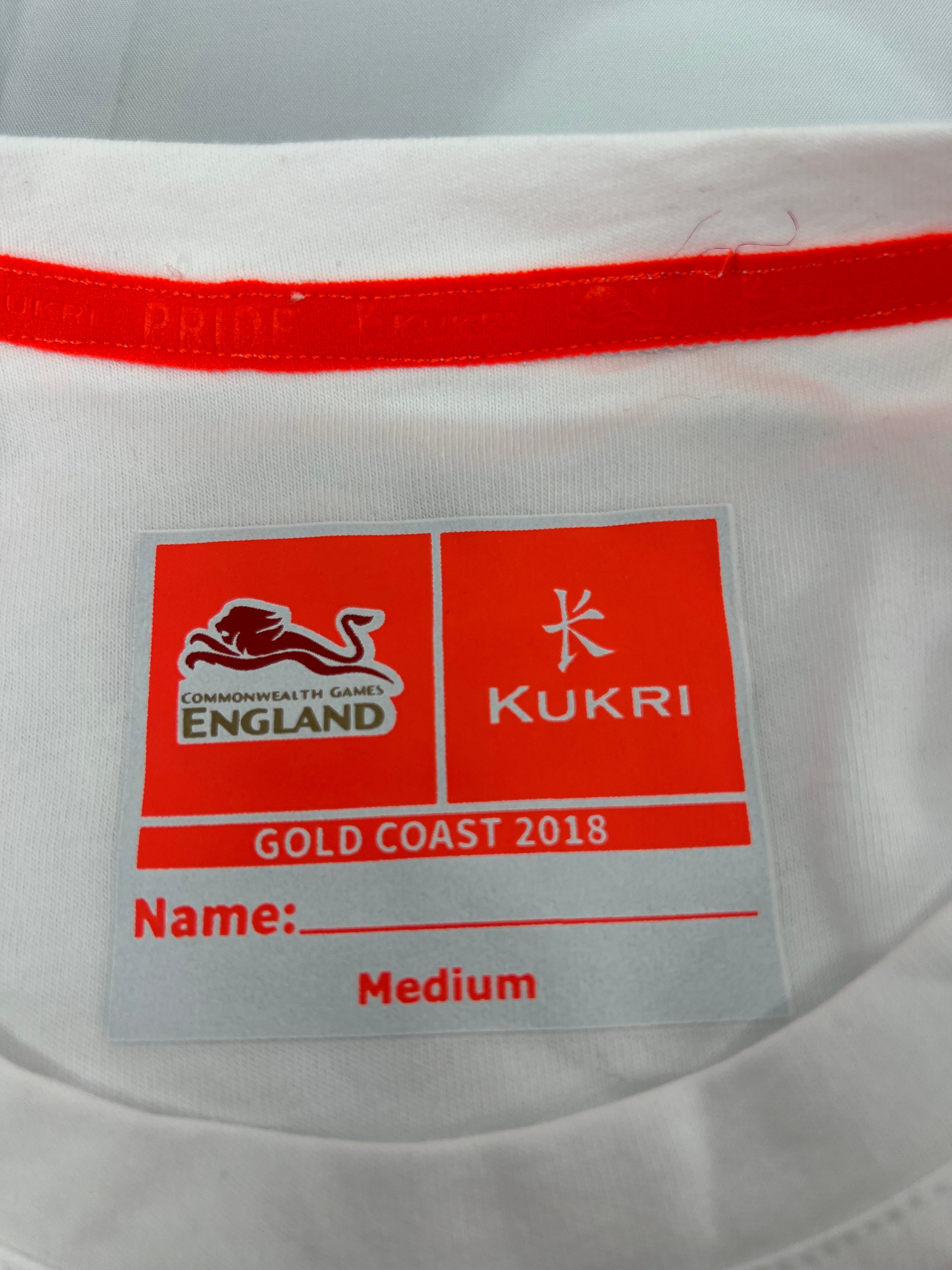 Close-up of Kukri and Commonwealth Games England logos with size tag showing medium size on t-shirt inside neckline