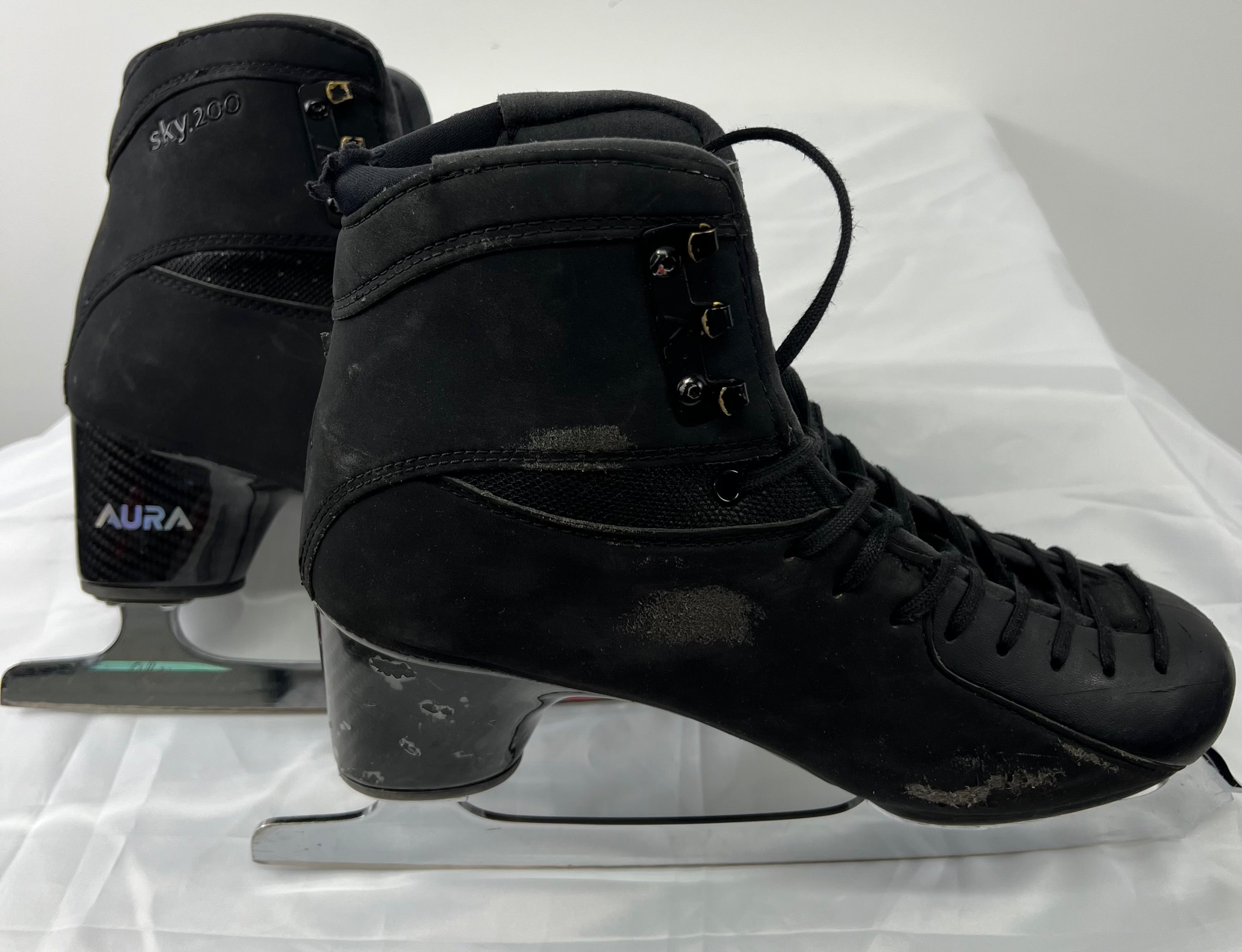 Side view of Aura SKY 200 figure skating boots showing laces and carbon fibre heel detailing