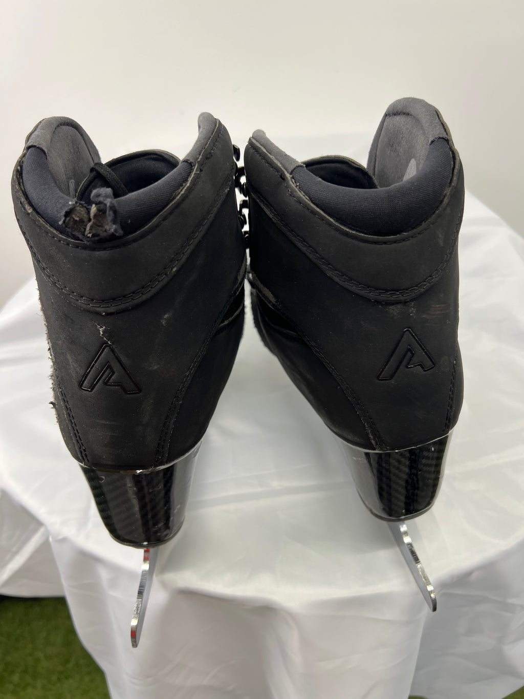 Rear view of Aura boots highlighting carbon fibre heels and logo embossed on back