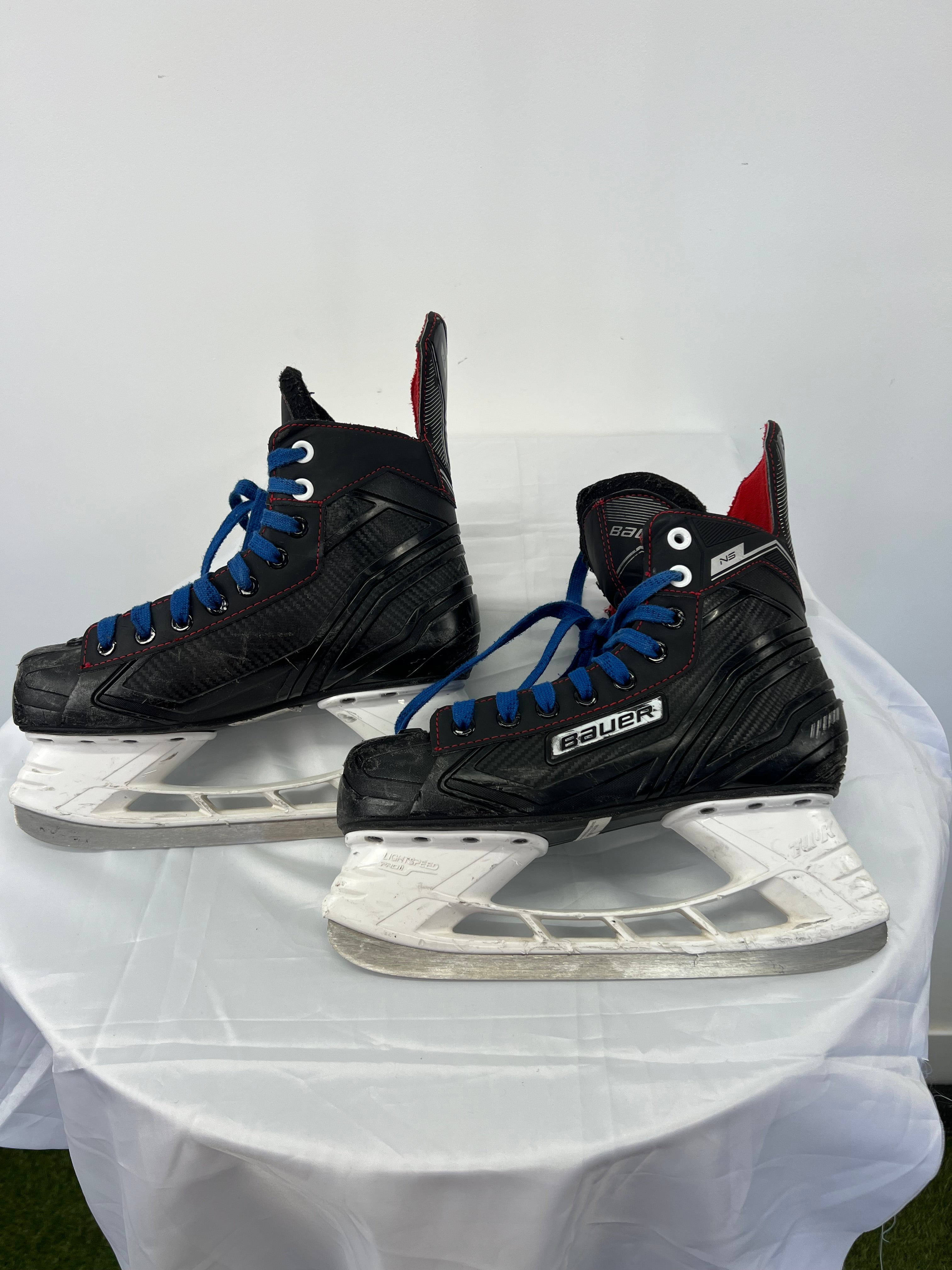 Side view of Bauer Light Speed 11 Pro ice hockey skates showing black body and white blade holders