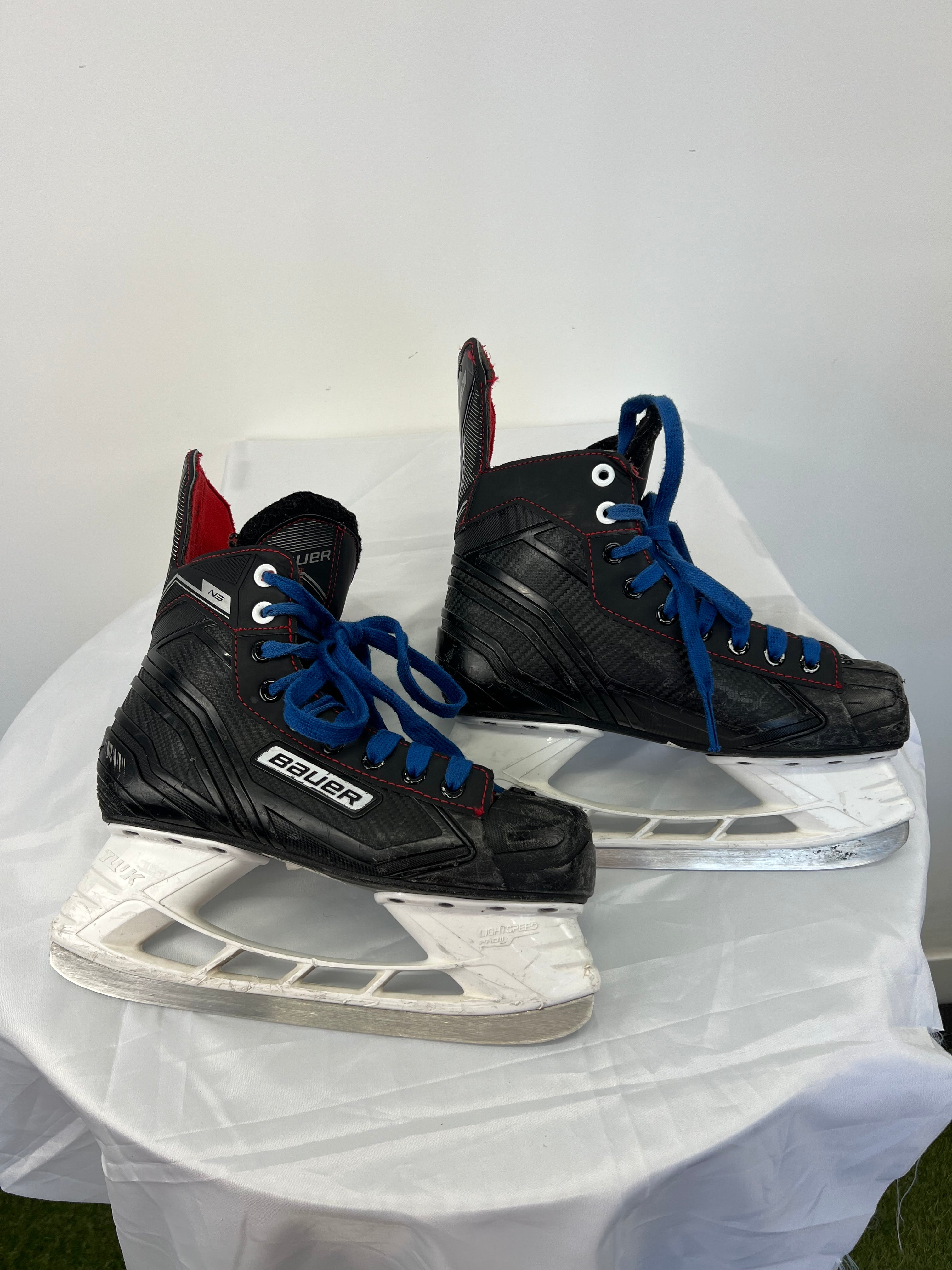 Opposite side view of Bauer Light Speed 11 Pro ice hockey skates featuring black textured design and blue laces