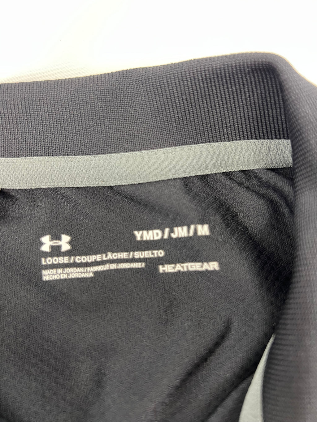 Close-up of inner label showing size and HeatGear branding on black polo