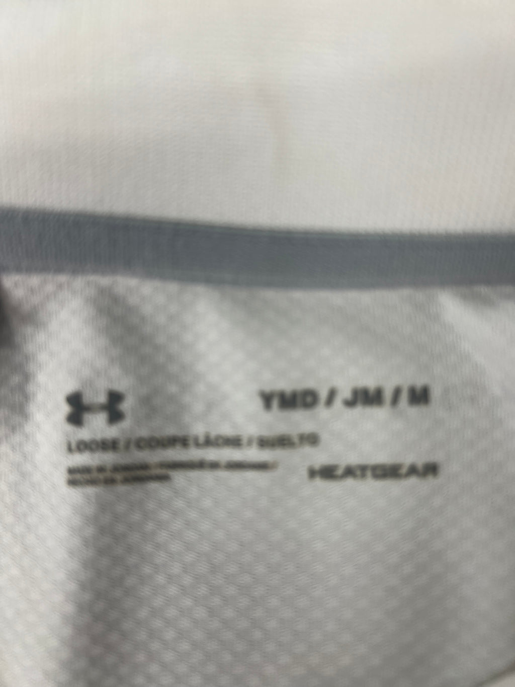 Close-up of inner label showing size and HeatGear branding on white polo
