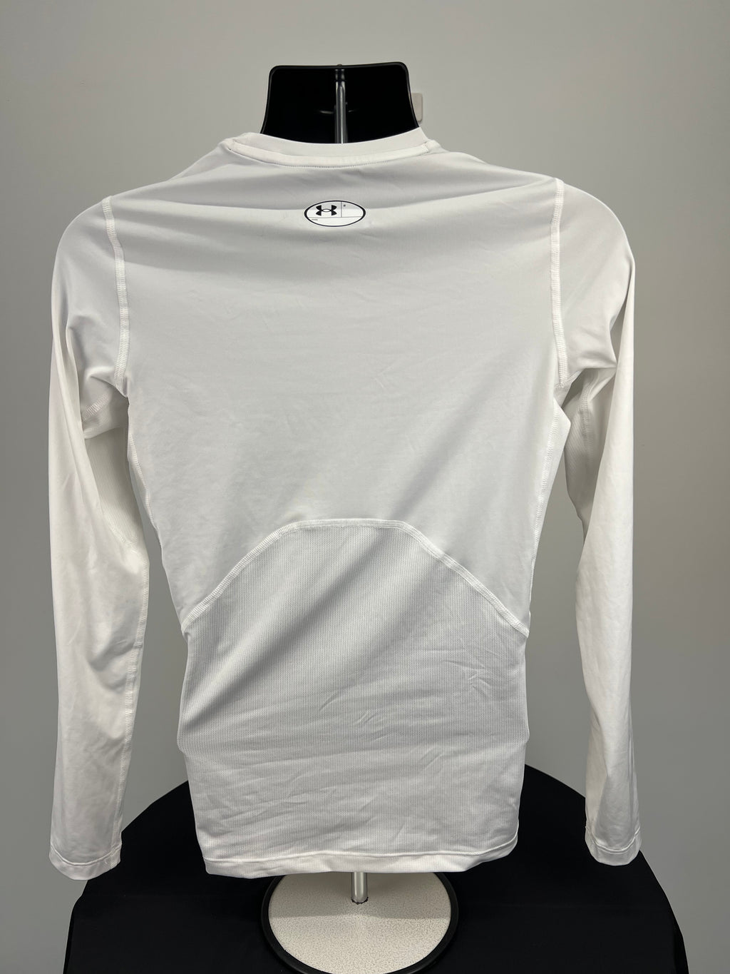 Rear view of white Under Armour men’s compression base layer long sleeve shirt showing mesh panels and logo
