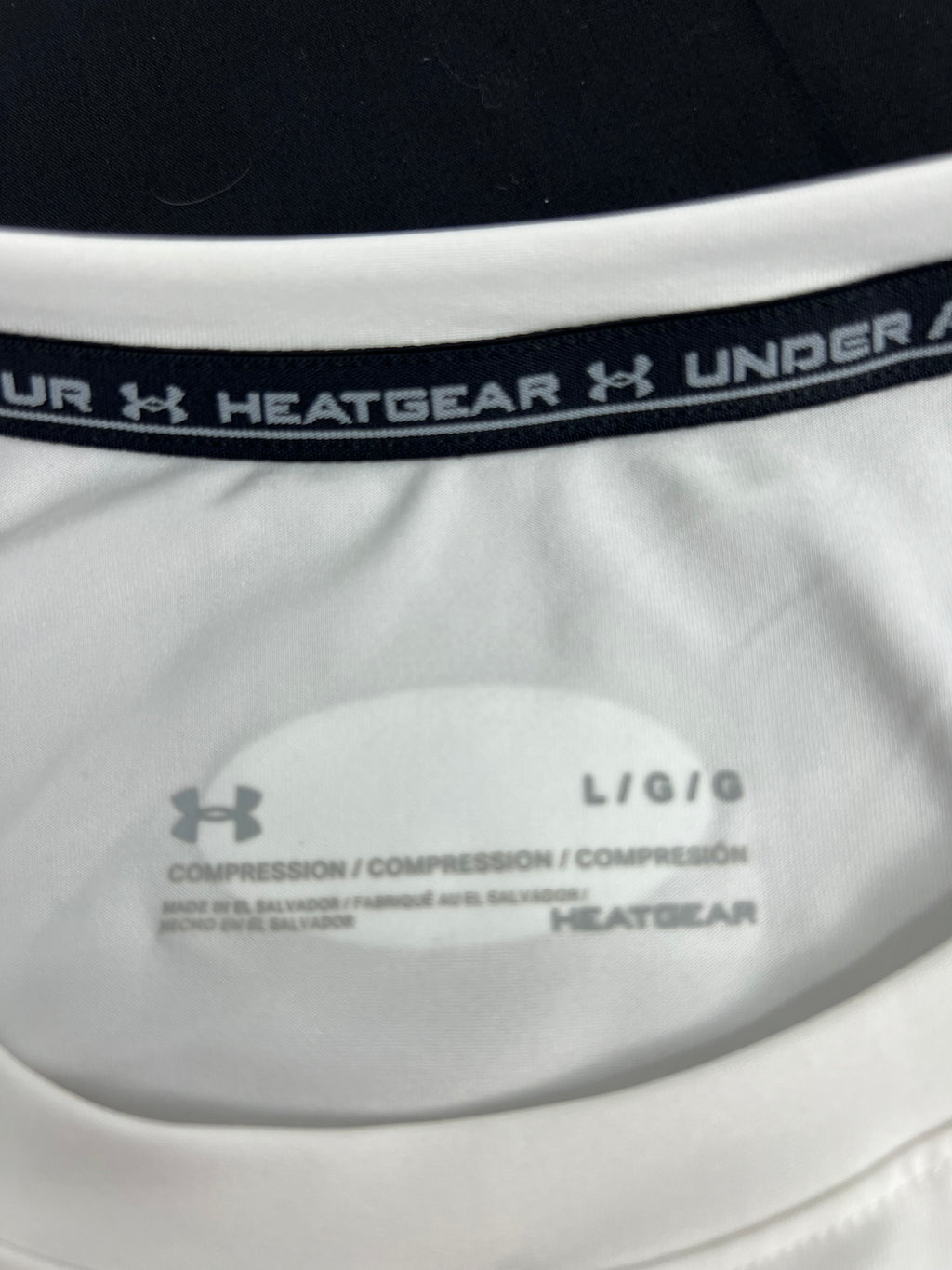 Close-up of the inside neck label showing Under Armour HeatGear compression and size L