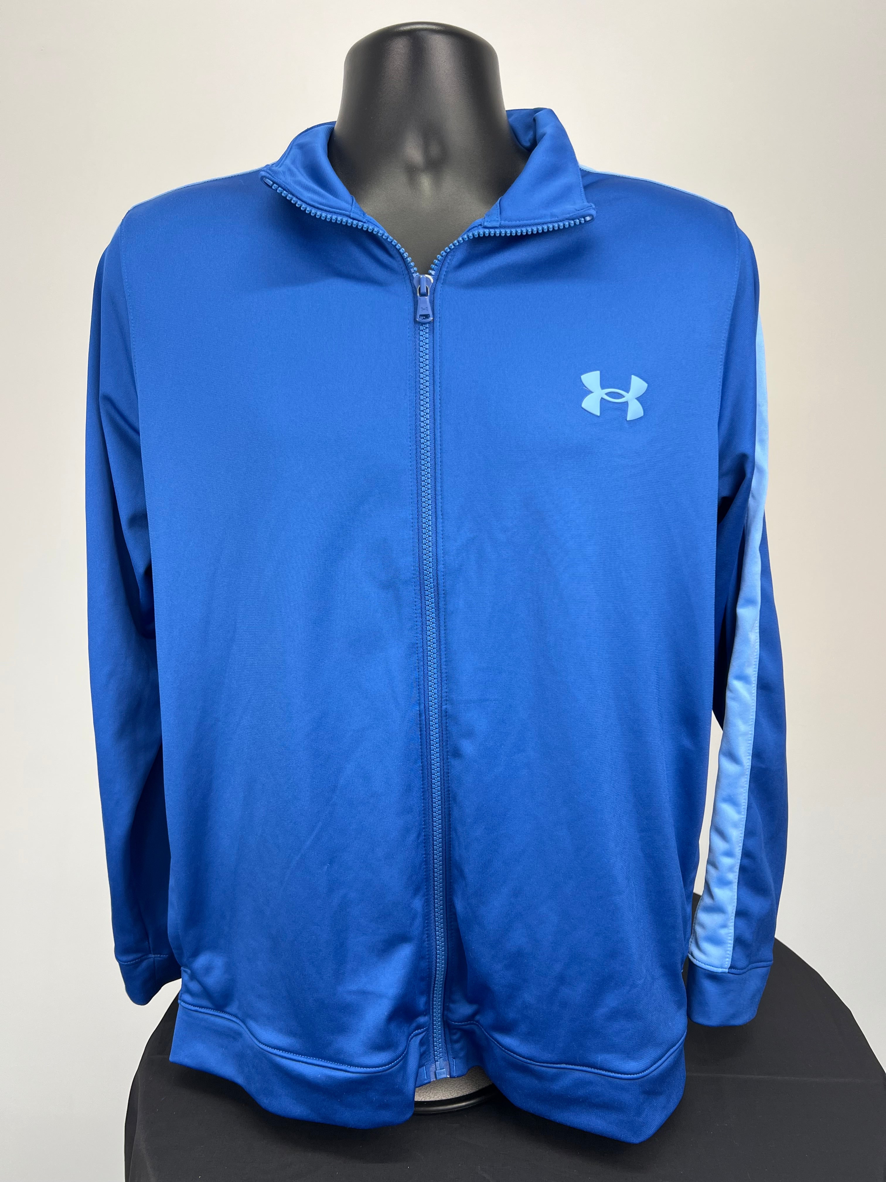 Front view of men's blue Under Armour track jacket with zipper and light blue sleeve stripe