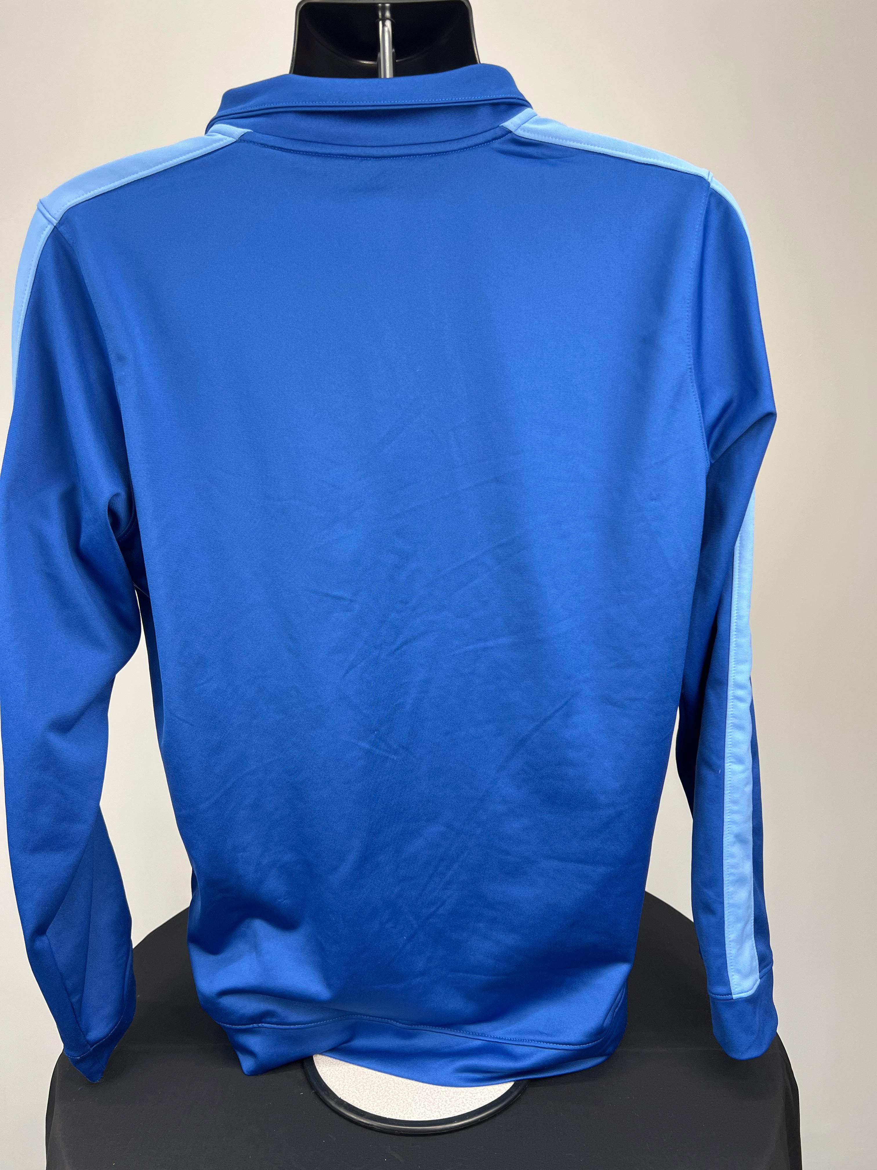 Back view of men's blue Under Armour track jacket showing light blue stripe along shoulders and sleeves