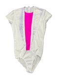Front view of white short sleeve figure skating leotard with bright pink centre panel and lilac snake-print accents on grass background