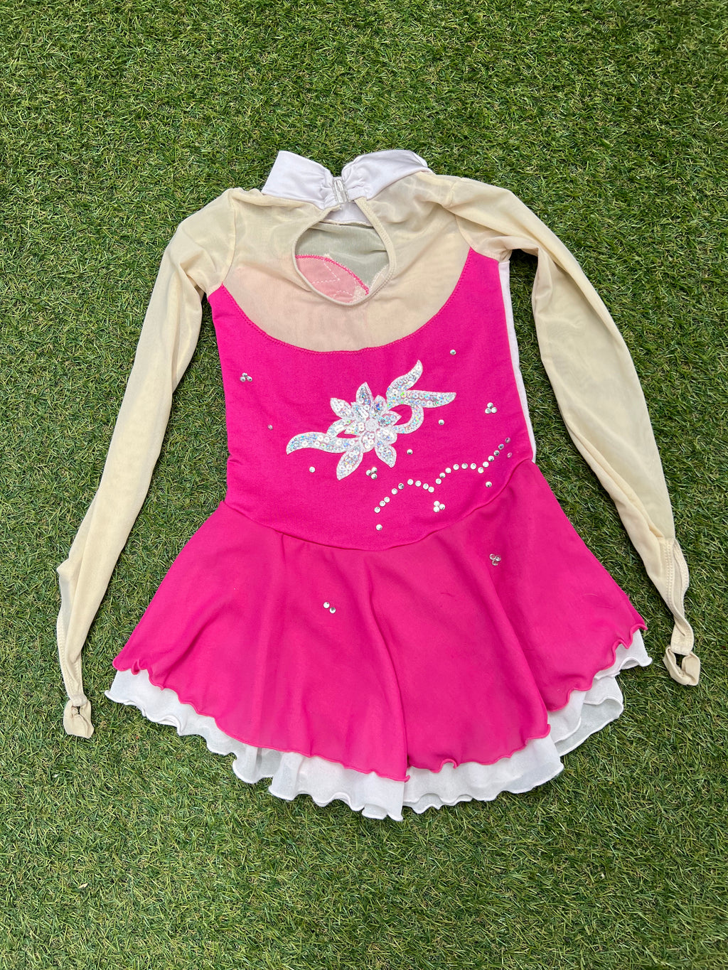 Back view of pink and cream long sleeve embellished kids ice skating dress with keyhole and zipper closure