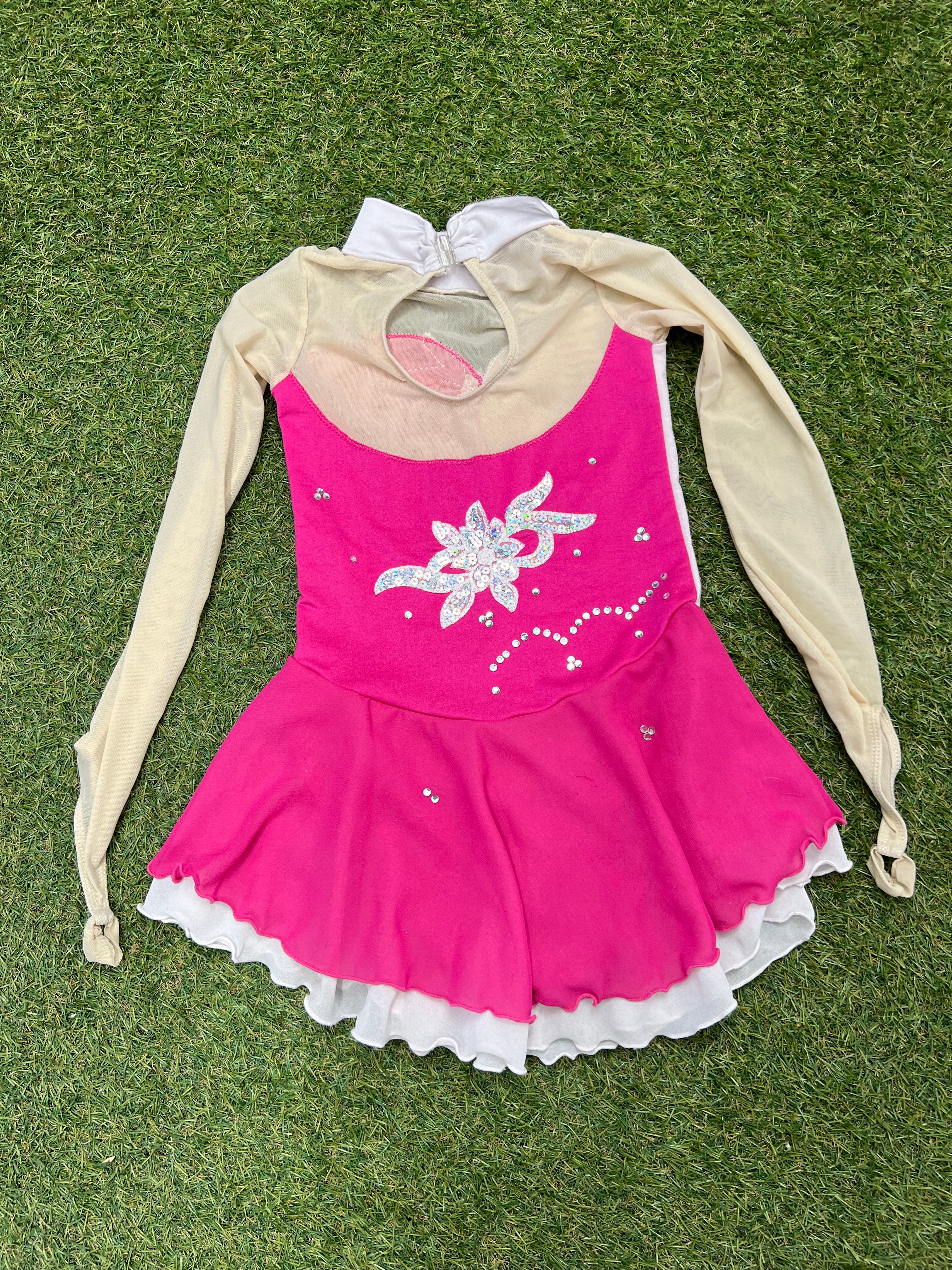 Back view of pink and cream long sleeve embellished kids ice skating dress with keyhole and zipper closure