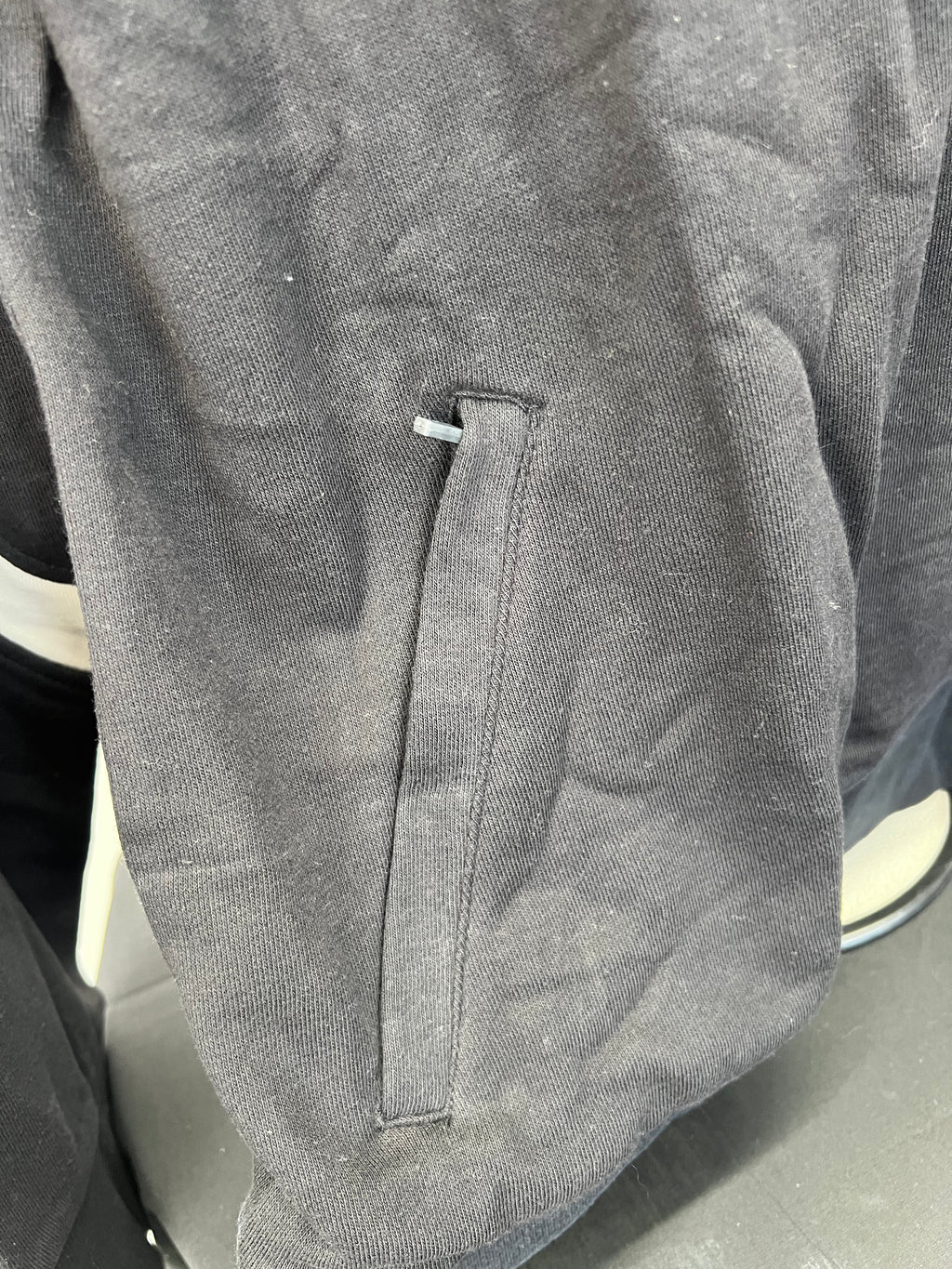 Close-up of side pocket detail on black Umbro sweatshirt
