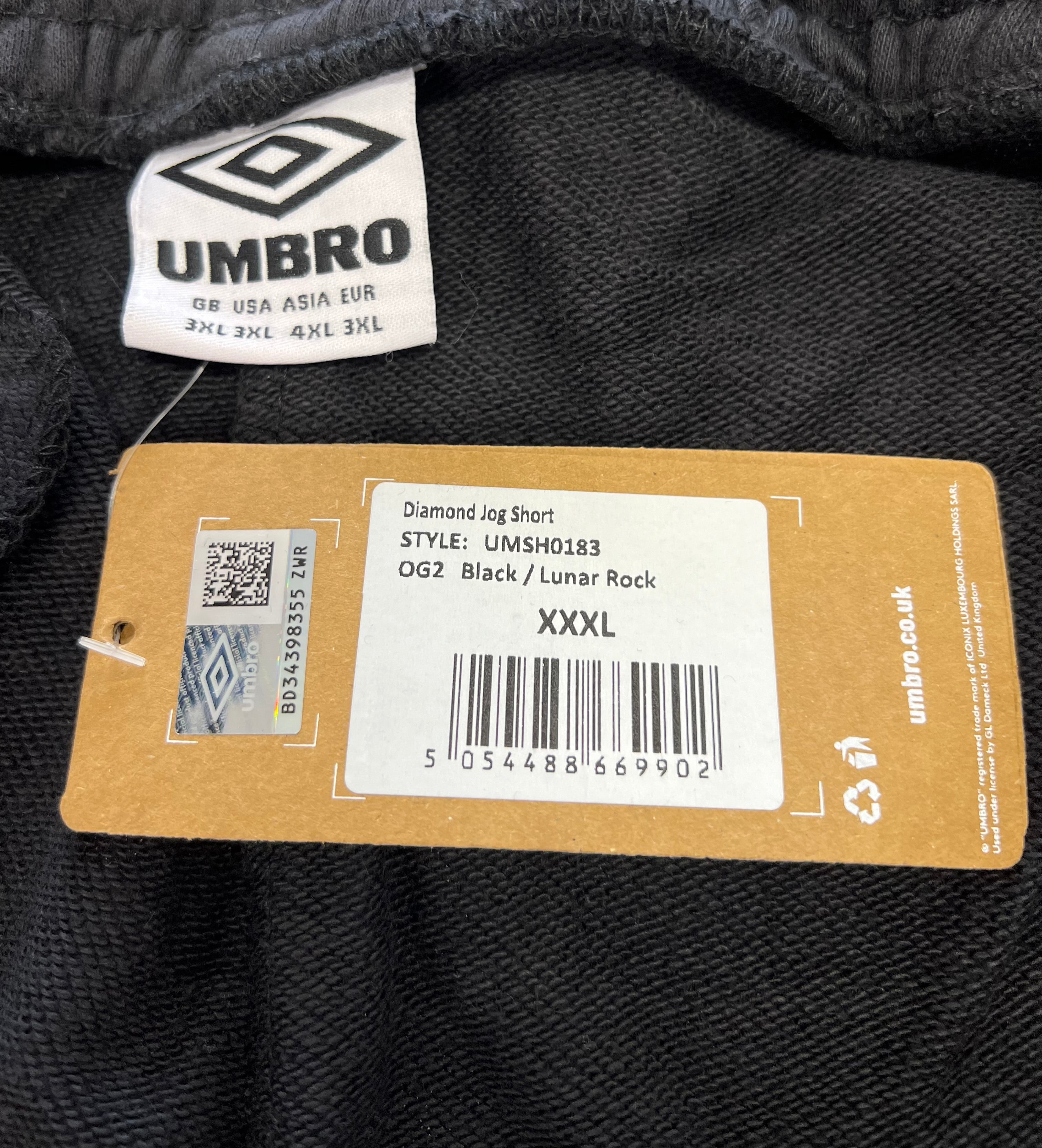 Close-up of Umbro label and product tag displaying size XXXL and style details