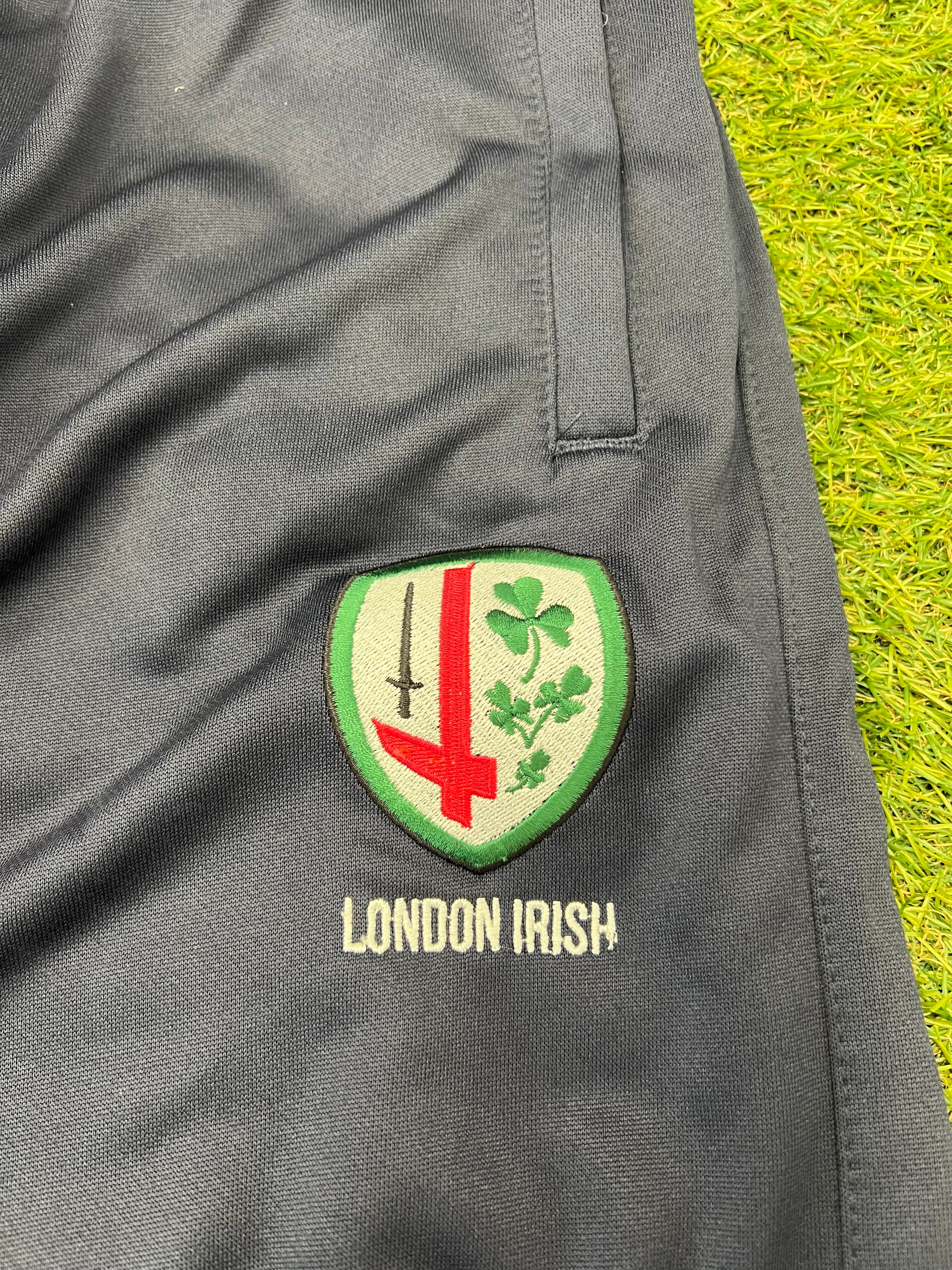 Close-up of embroidered London Irish crest on black tracksuit trousers