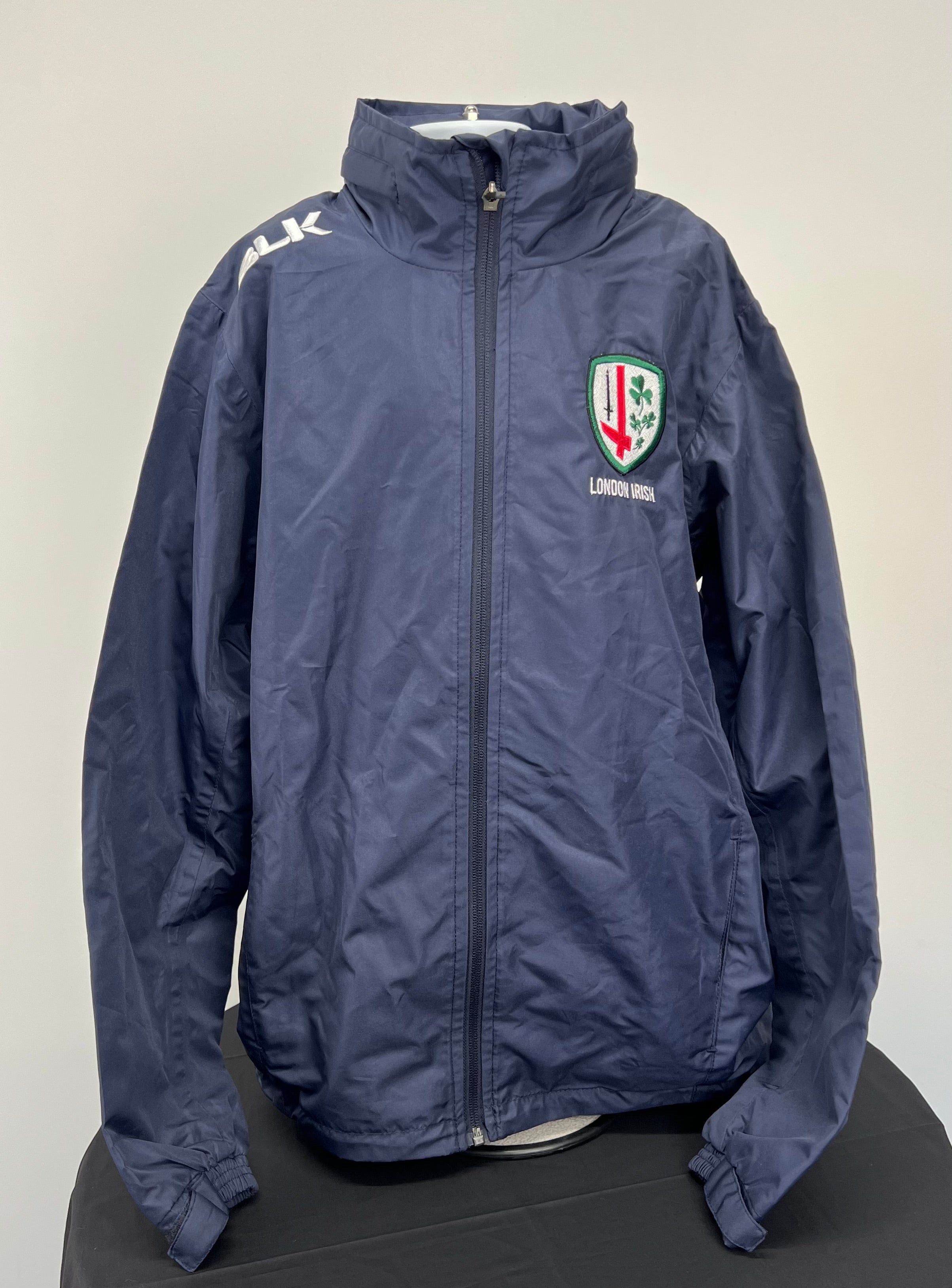 Front view of navy Youth London Irish lightweight jacket with zipper and embroidered London Irish logo