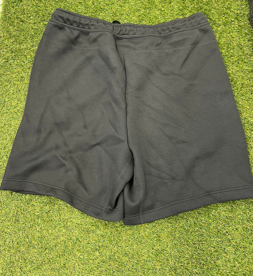 Back view of plain black Nike men's shorts laid flat on grass
