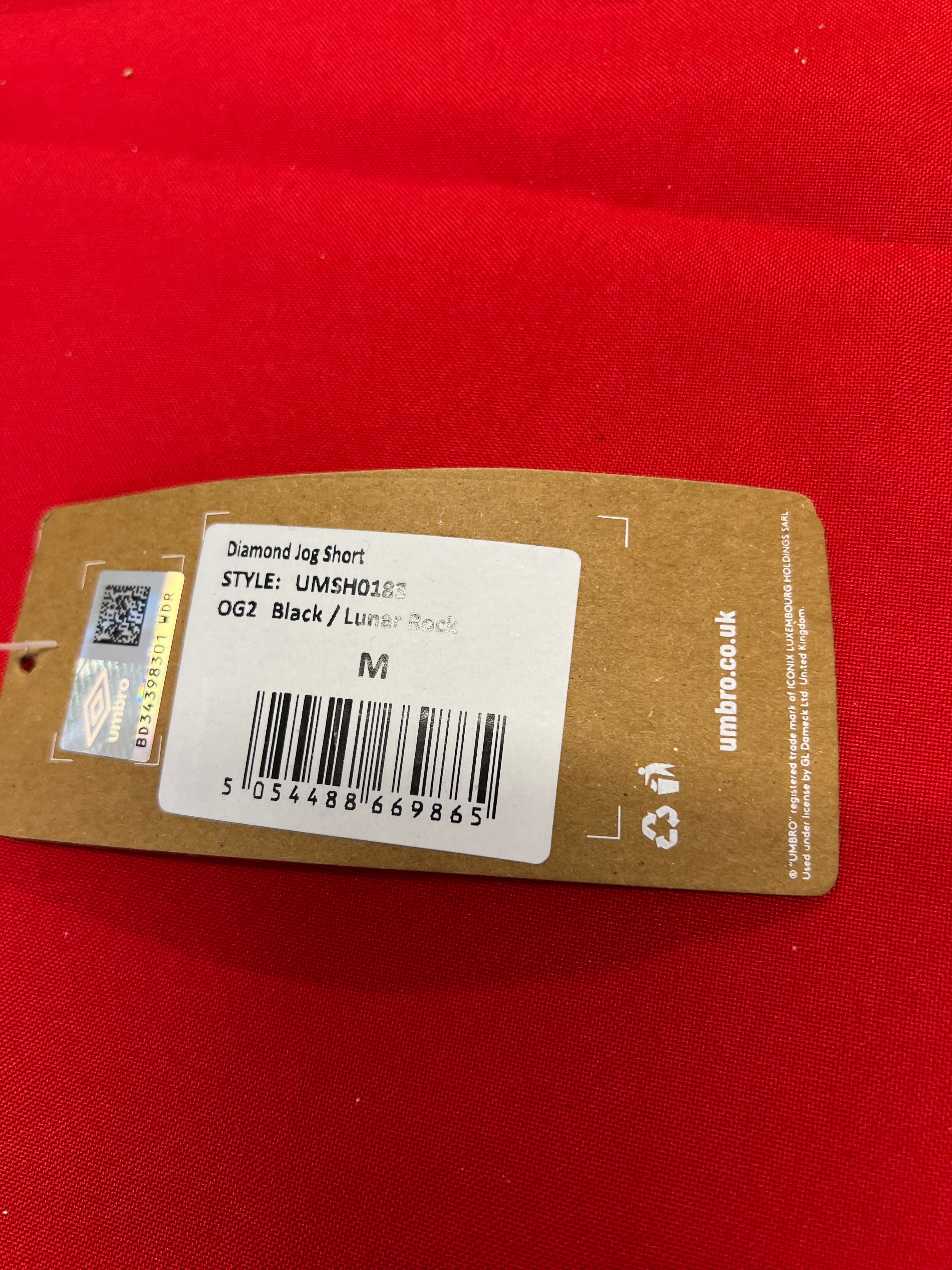 Close-up of Umbro Diamond Jog Short product tag showing size medium and style information