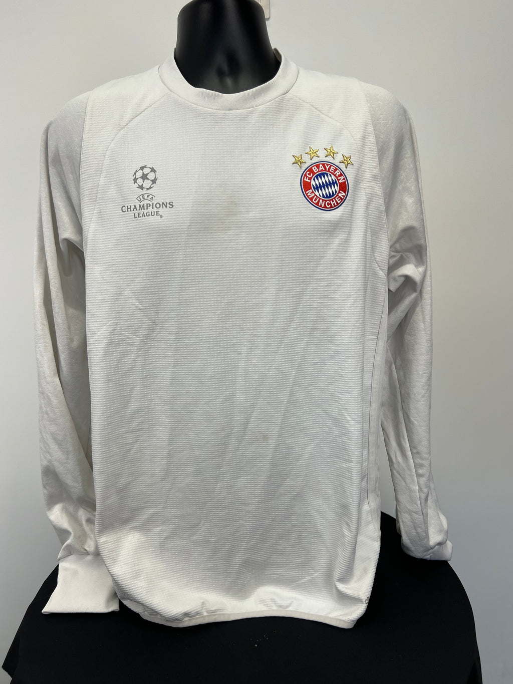 Front view of Adidas FC Bayern Munich white long sleeve top with UEFA Champions League and team logos
