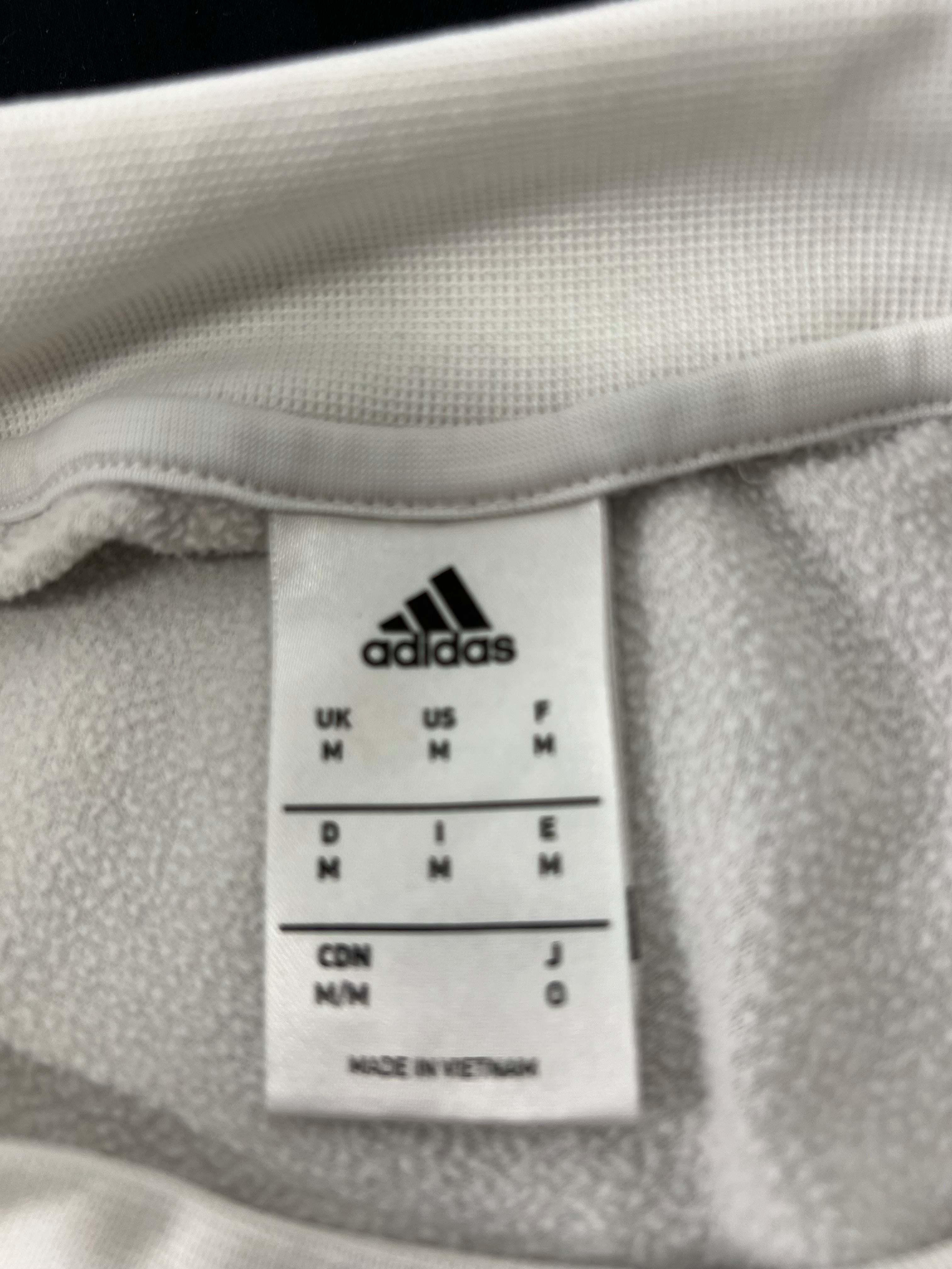 Manufacturer label inside Adidas long sleeve top showing size medium and made in Vietnam
