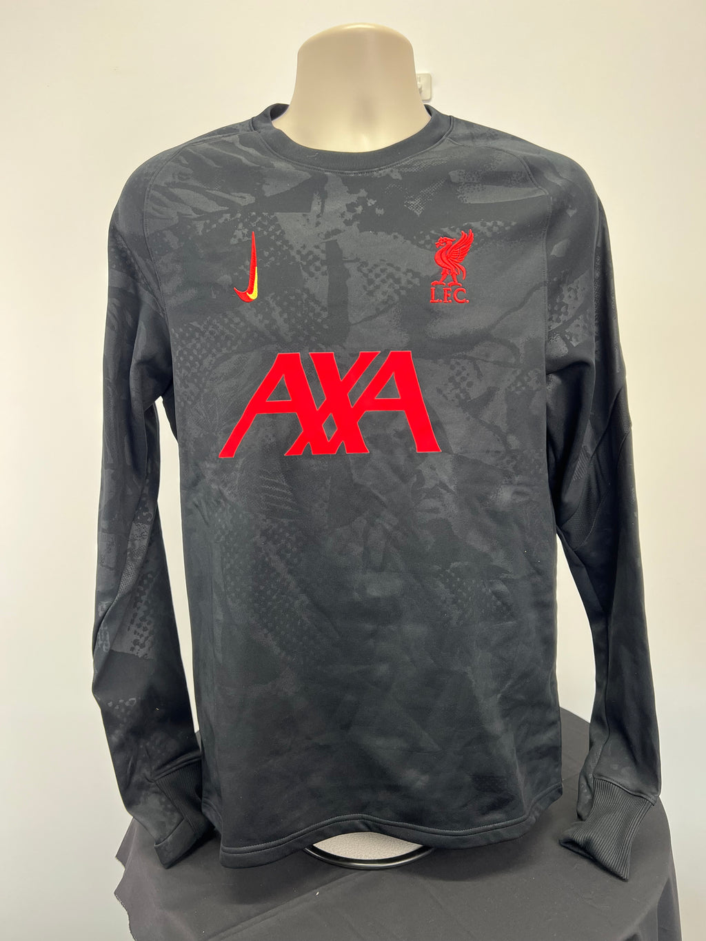Front view of Nike Liverpool FC long sleeve training top with red logos and subtle dark pattern