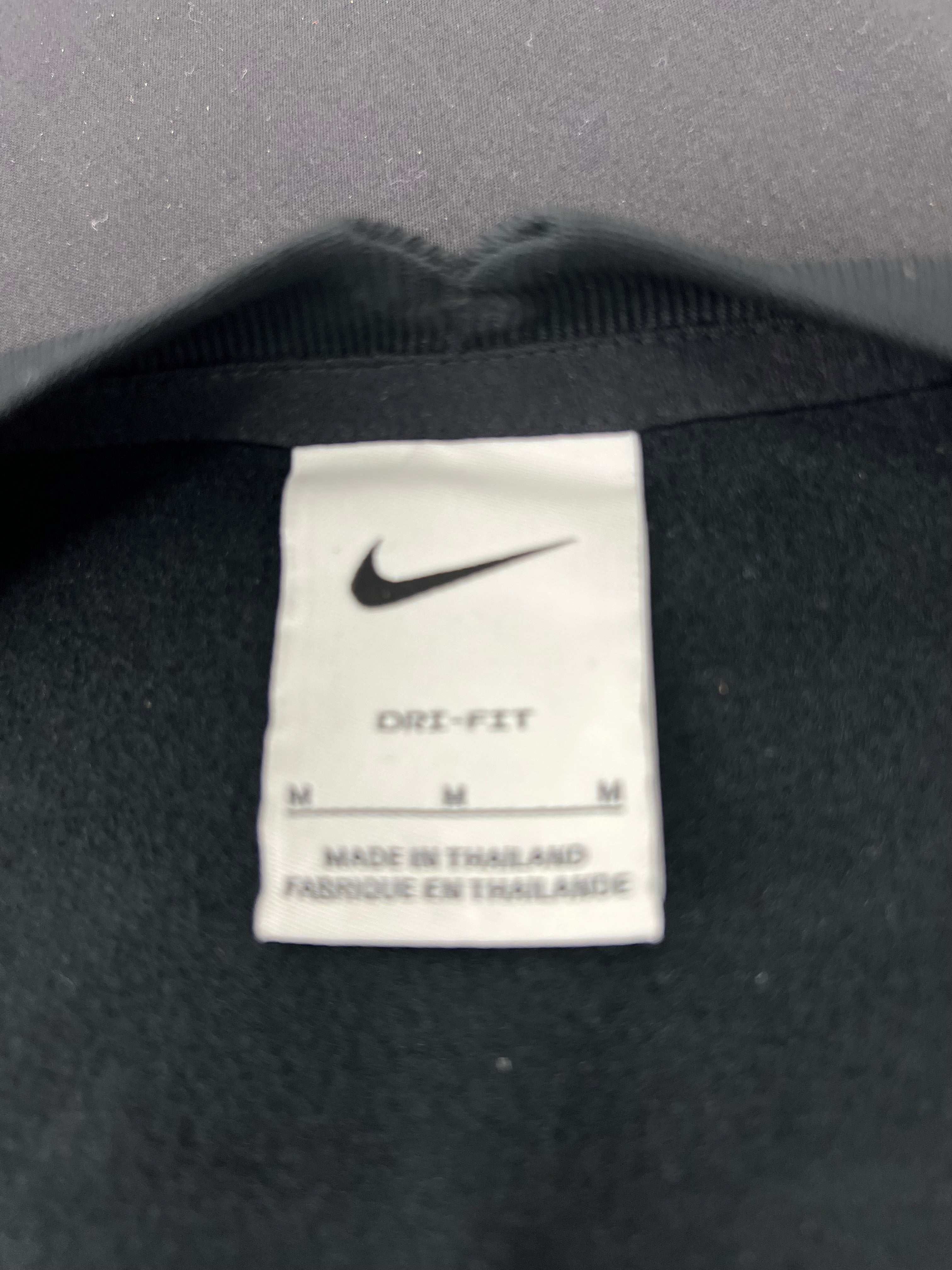 Inside neck label showing Nike Dri-FIT size M made in Thailand