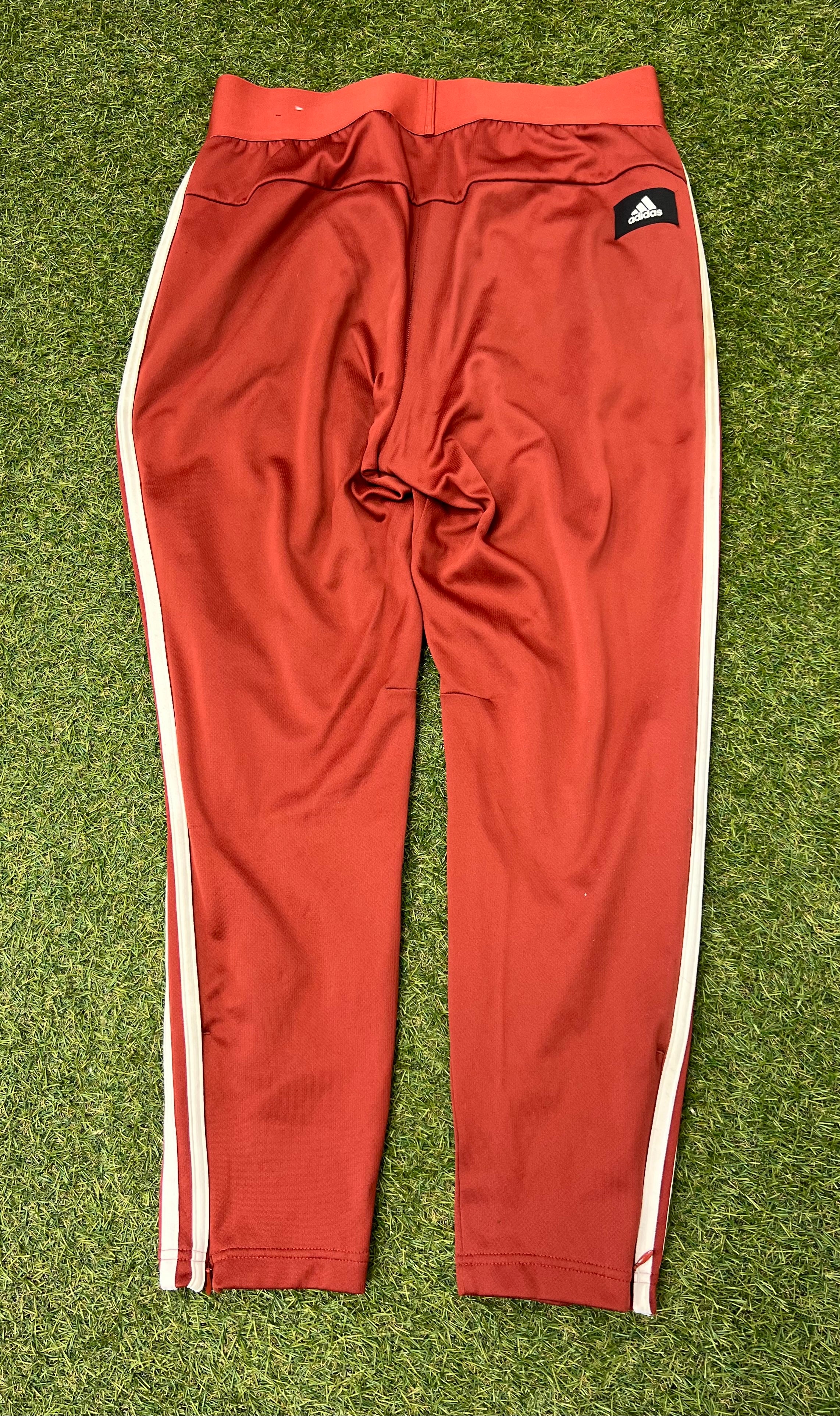 Back view of red Adidas women's tracksuit bottoms featuring elastic waistband and Adidas logo patch