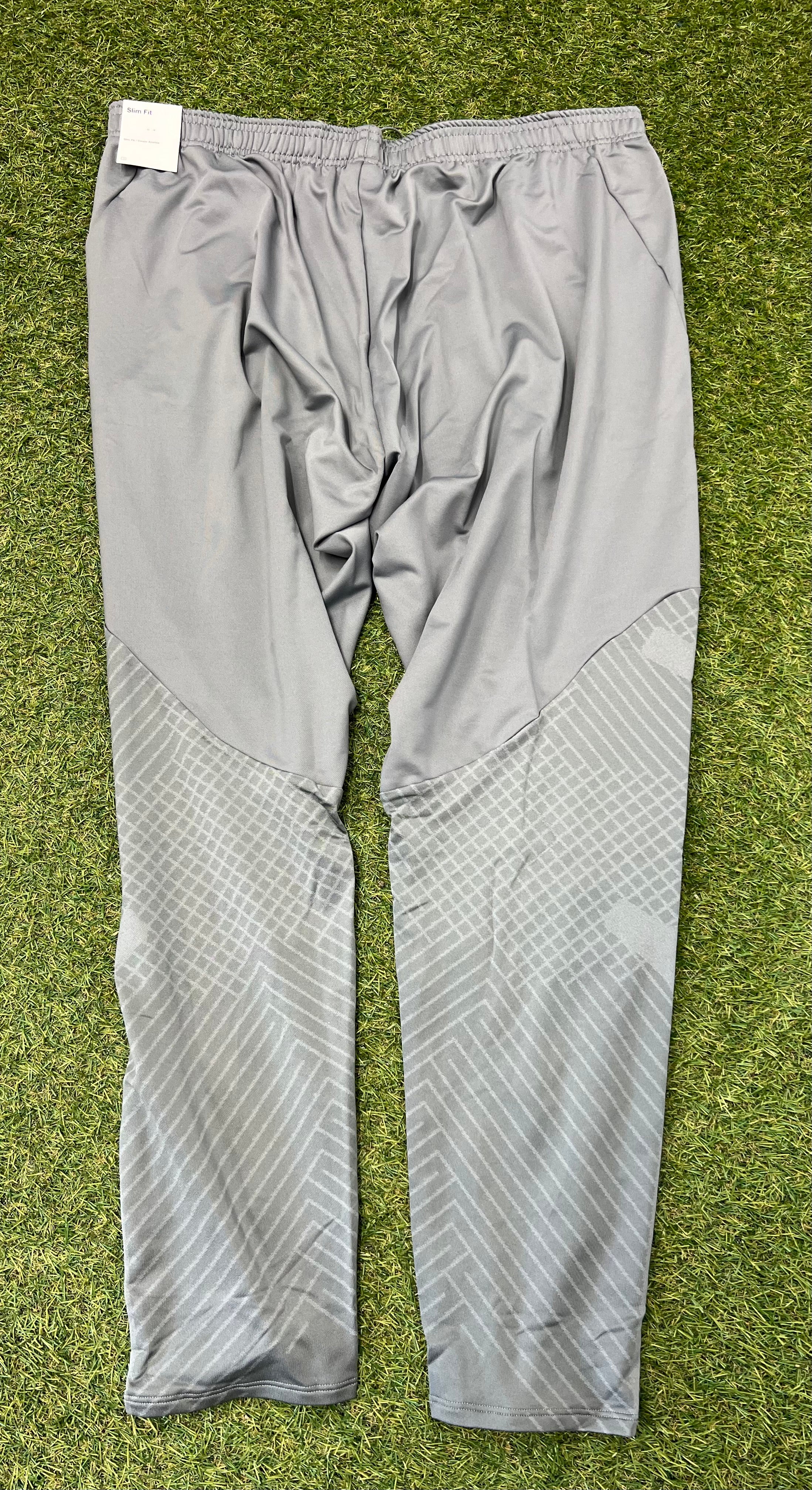Rear view of grey slim fit tracksuit bottoms showing patterned lower leg panels