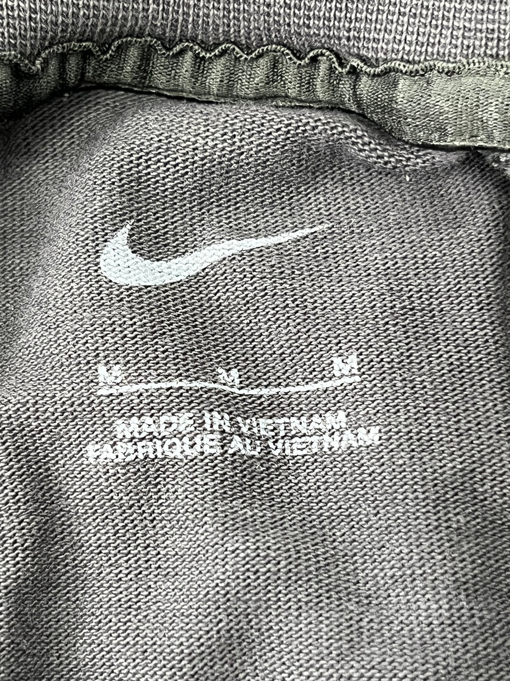 Close-up of Nike logo and fabric texture inside Liverpool FC t-shirt showing made in Vietnam label