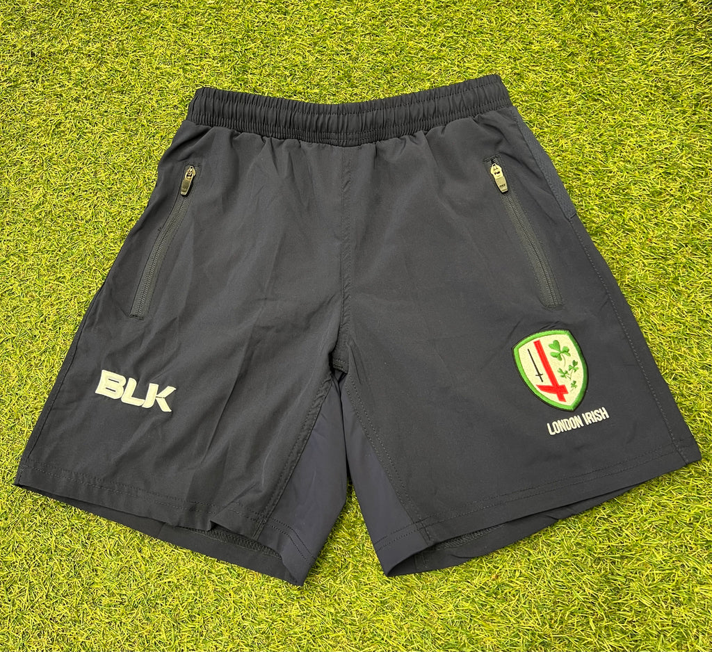 Front view of black BLK London Irish youth sports shorts with zipped pockets and logos.