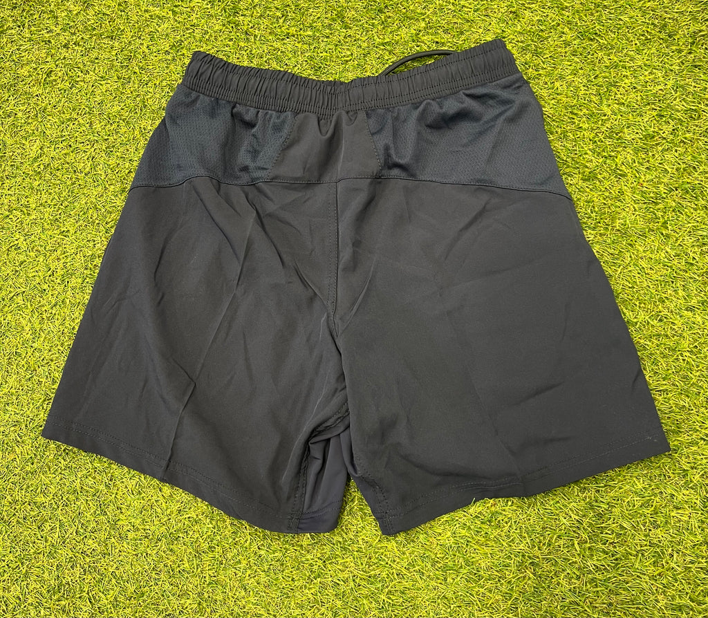 Back view of black BLK London Irish youth sports shorts showing mesh panels and elastic waistband.