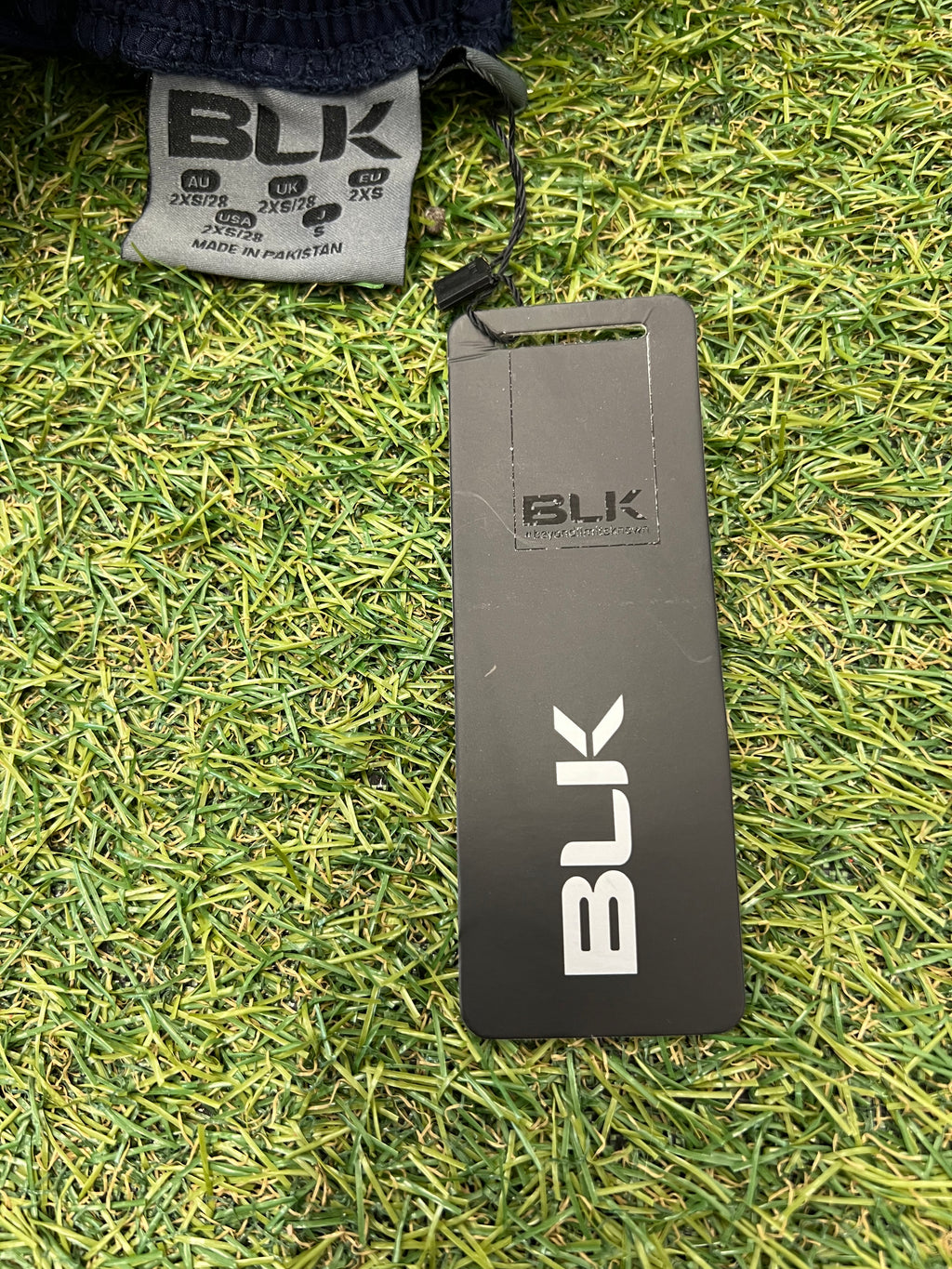Close-up of BLK brand tag and size label on the shorts.