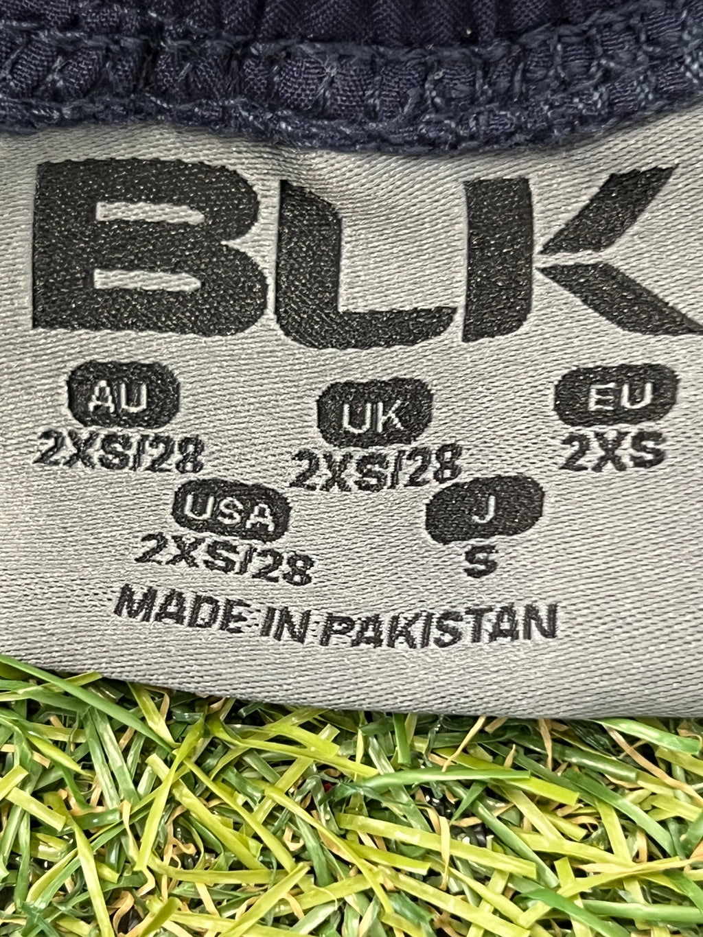 Close-up of inner label showing size 2XS and made in Pakistan information.