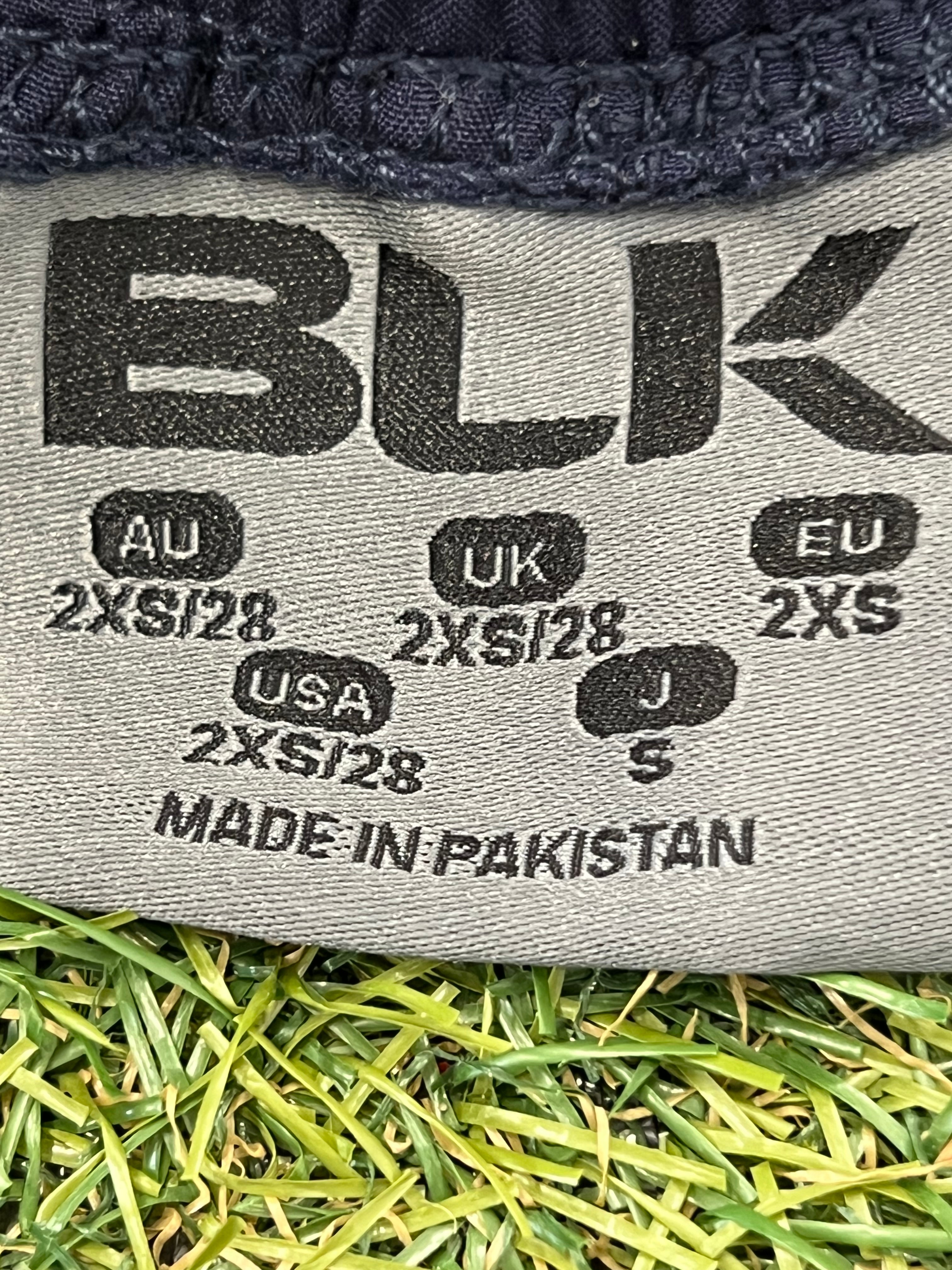 Close-up of inner label showing size 2XS and made in Pakistan information.