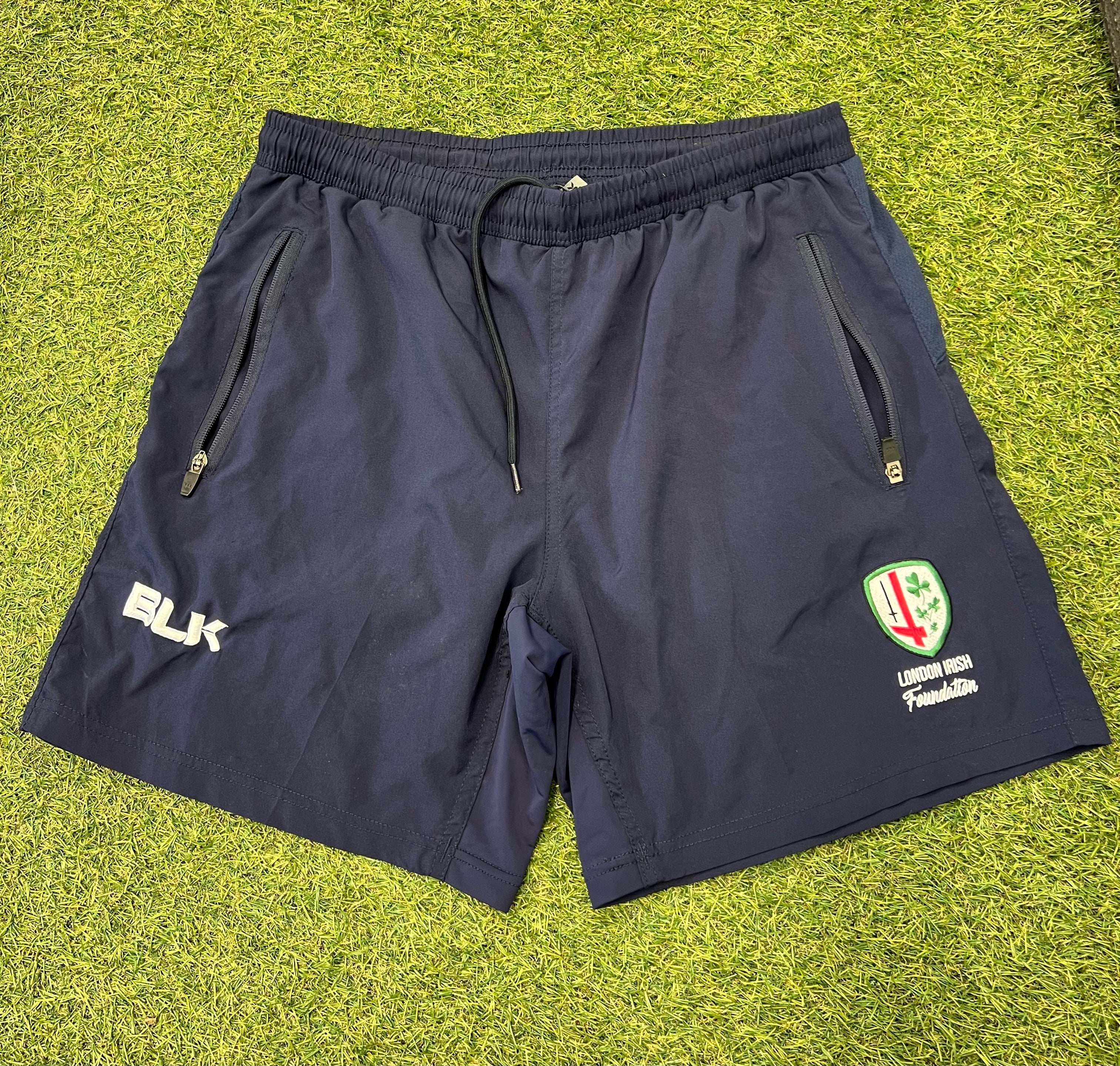 Front view of navy blue London Irish men's training shorts by BLK featuring zip pockets and team emblem