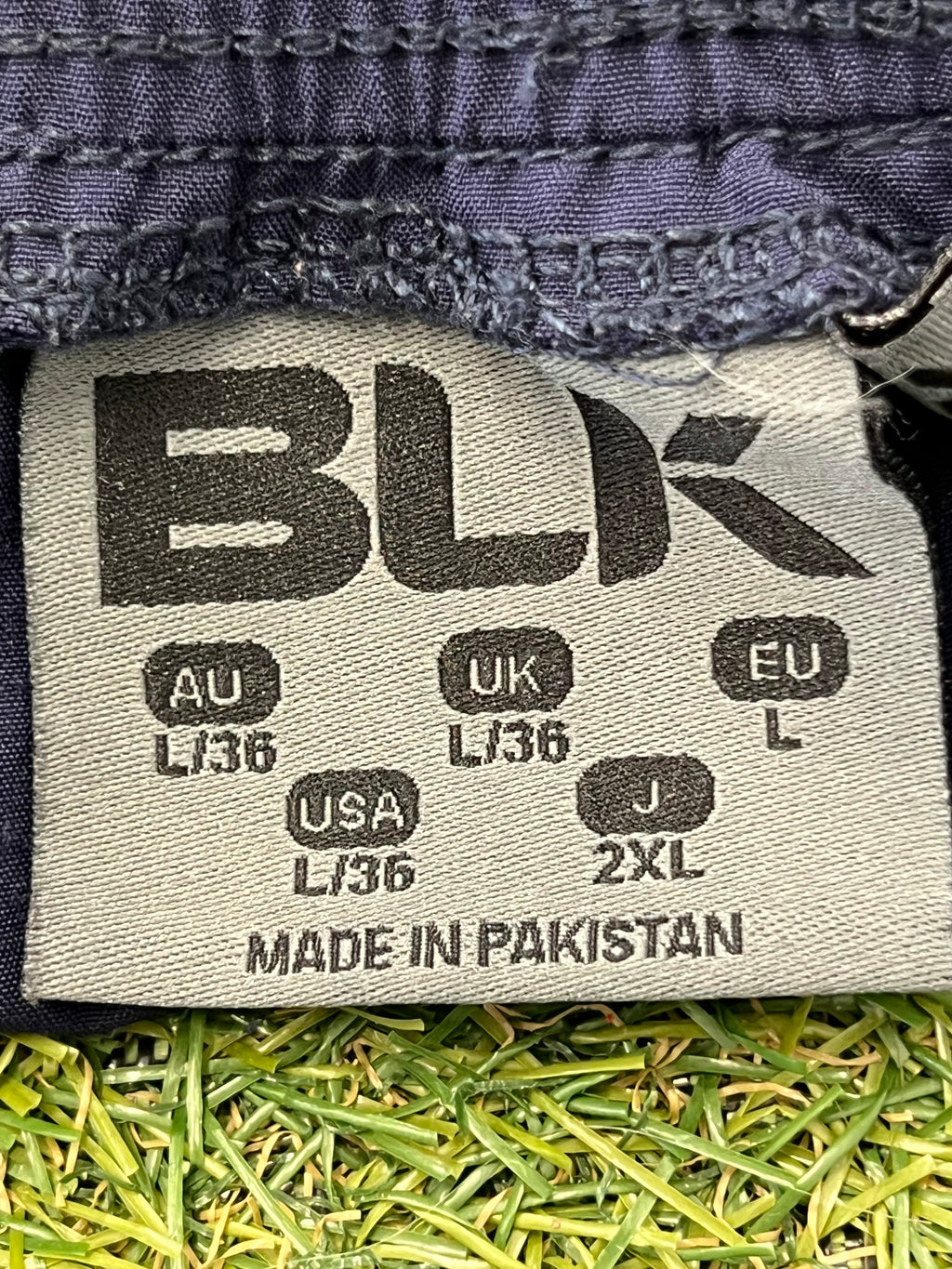 Close-up of size label inside London Irish men's training shorts by BLK showing multiple regional sizes