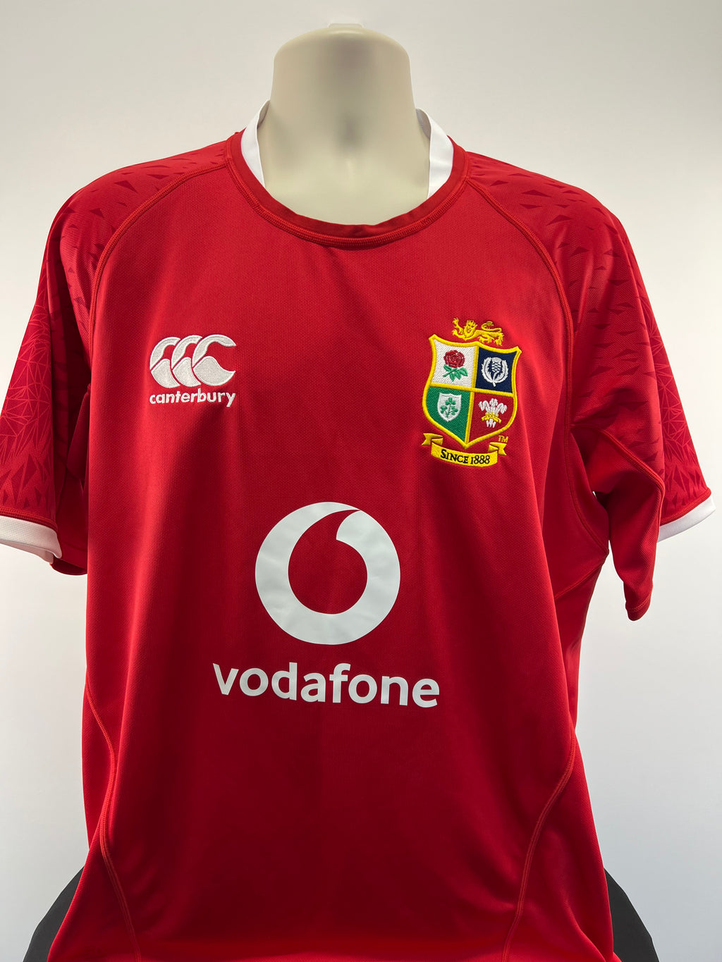 Front view of Canterbury Lions Rugby Shirt in red with Lions crest and Vodafone logo