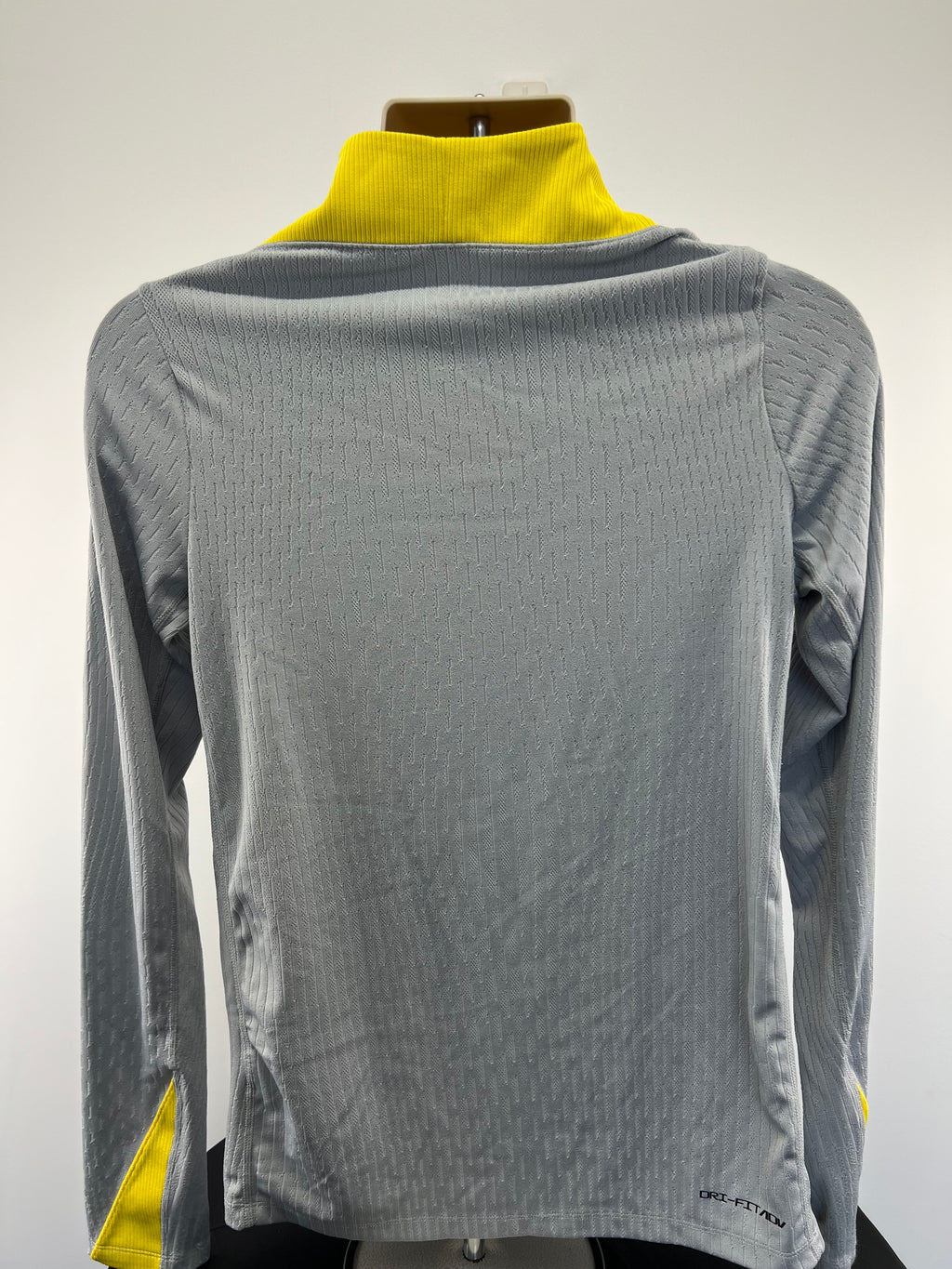 Back view of Liverpool FC grey top with yellow ribbed collar and thumb holes on sleeves