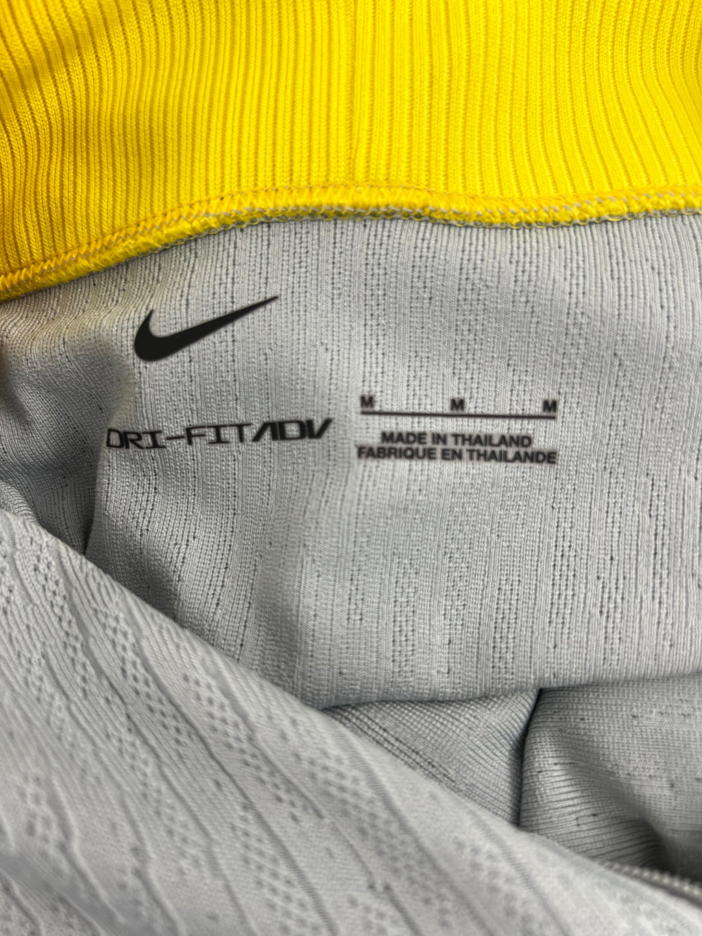 Close-up image of inside label showing Nike Dri-FIT ADV branding and size M