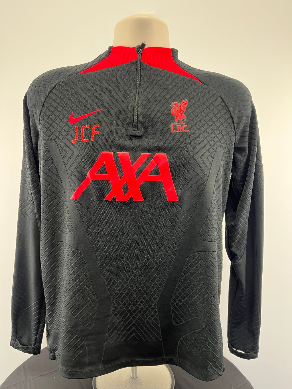 Front view of Liverpool FC black long sleeve training top with red details and zipper by Nike