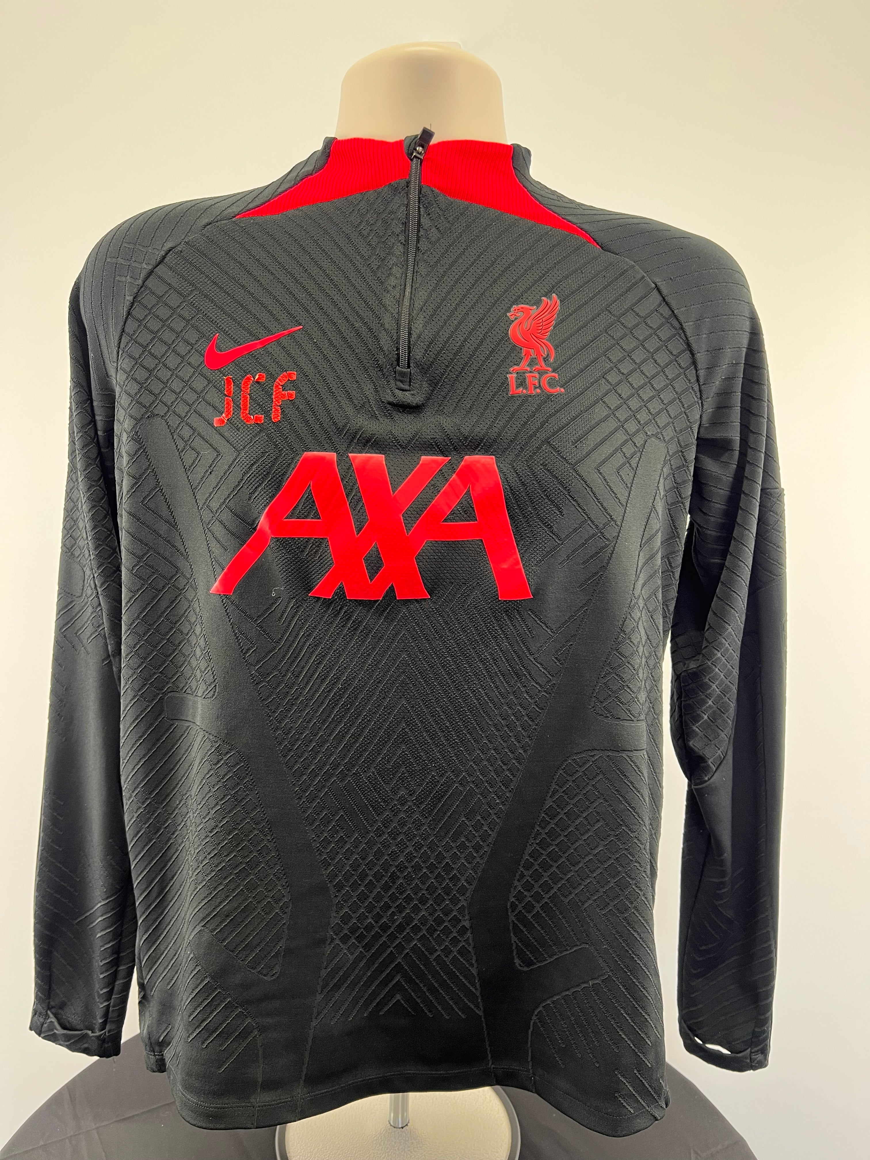 Front view of Liverpool FC black long sleeve training top with red details and zipper by Nike