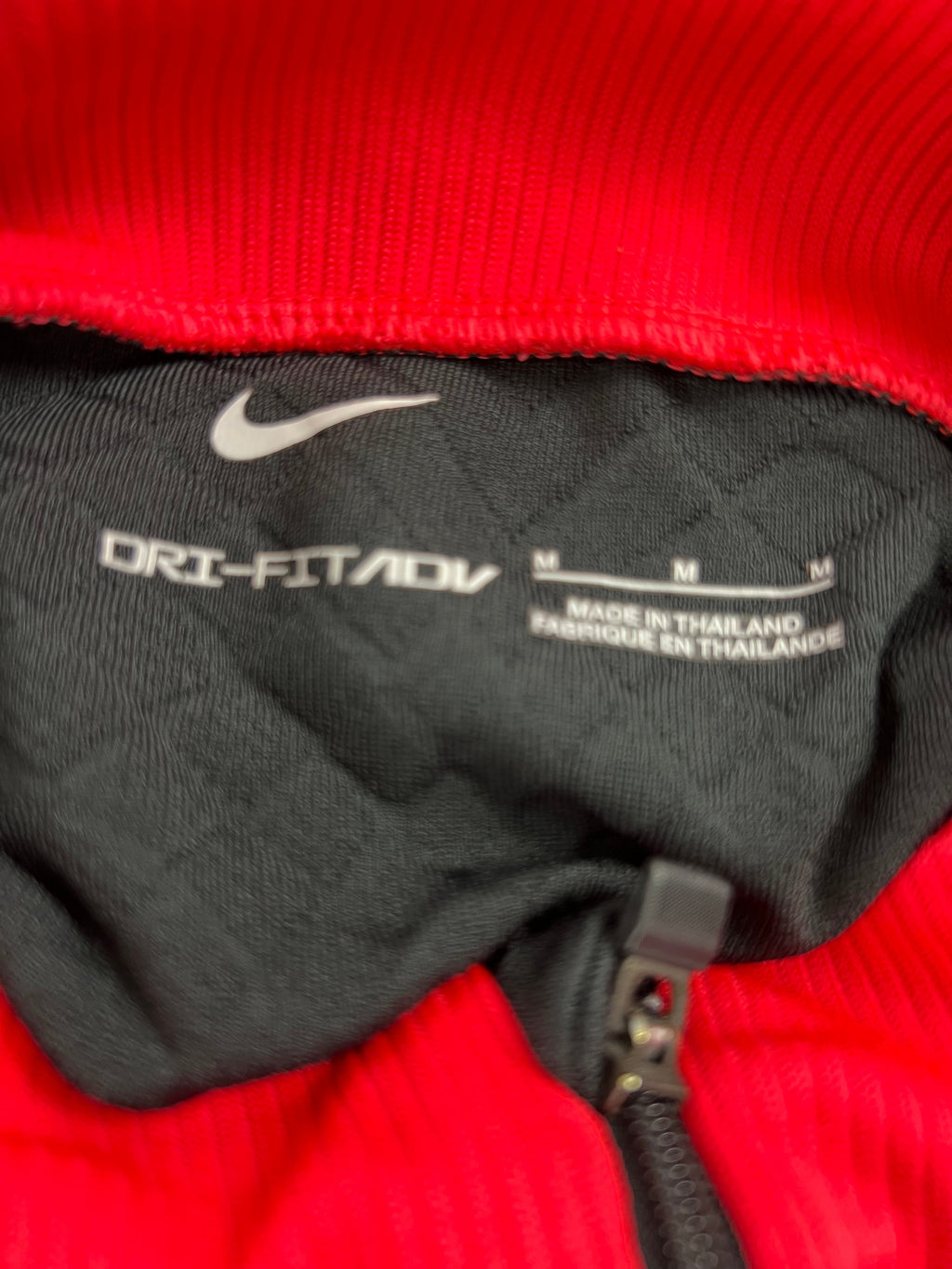 Close-up of interior label showing Nike Dri-FIT branding and size information on Liverpool FC top