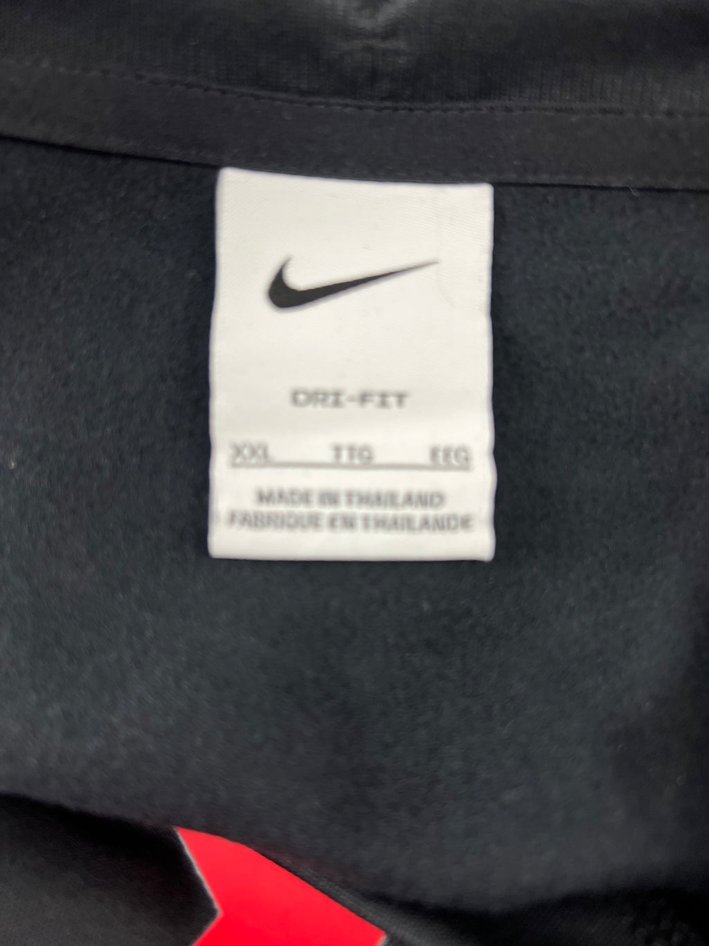 Close-up of white Nike Dri-FIT label inside Liverpool FC training top showing size XXL made in Thailand