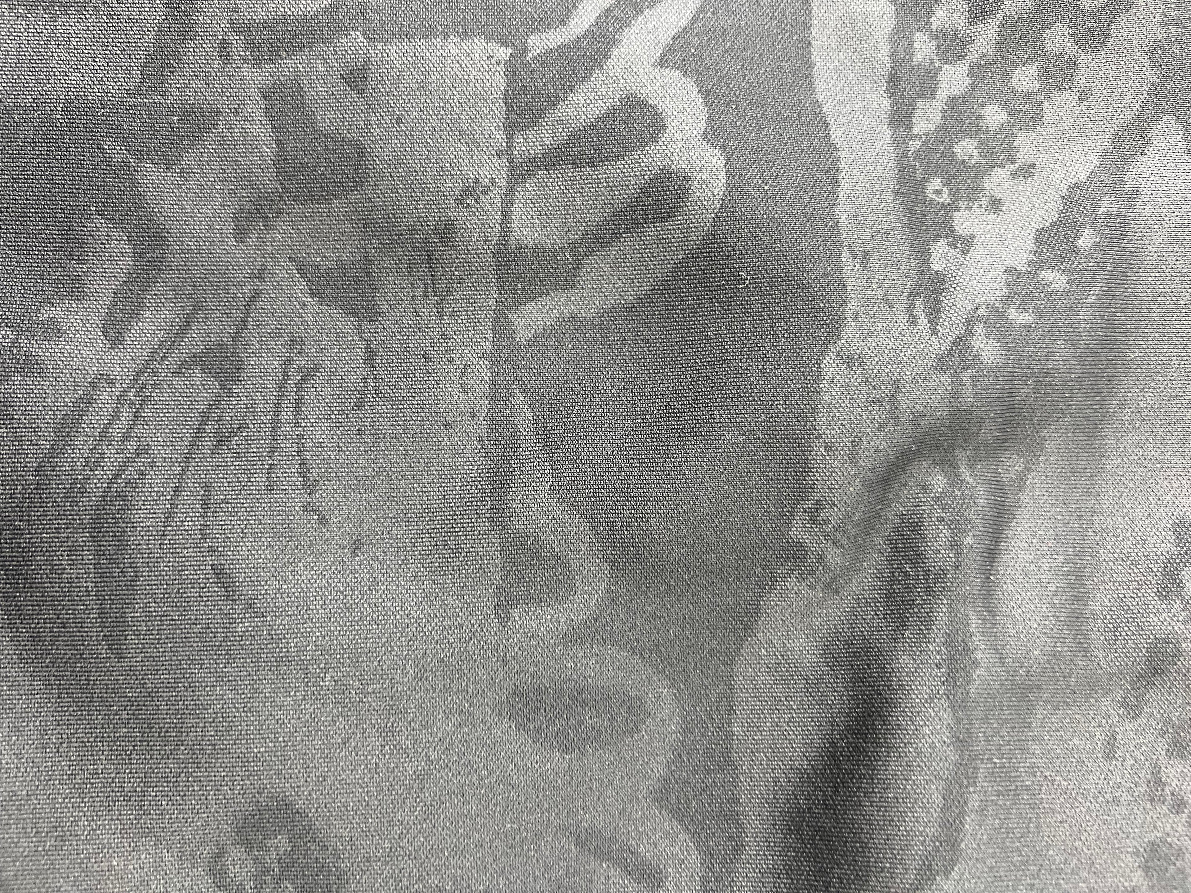 Detailed close-up of subtle tonal graphic pattern on black fabric of Liverpool FC training top