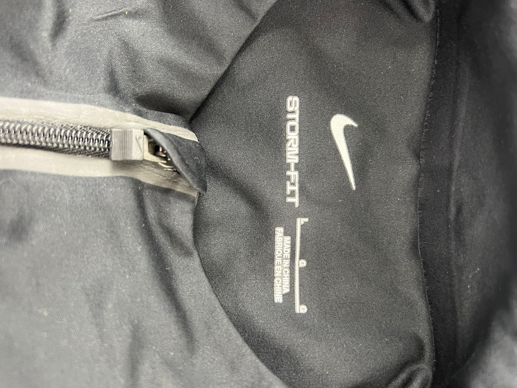 Close-up of inside neck label showing Nike Storm-FIT branding and fabric details on Liverpool FC training top