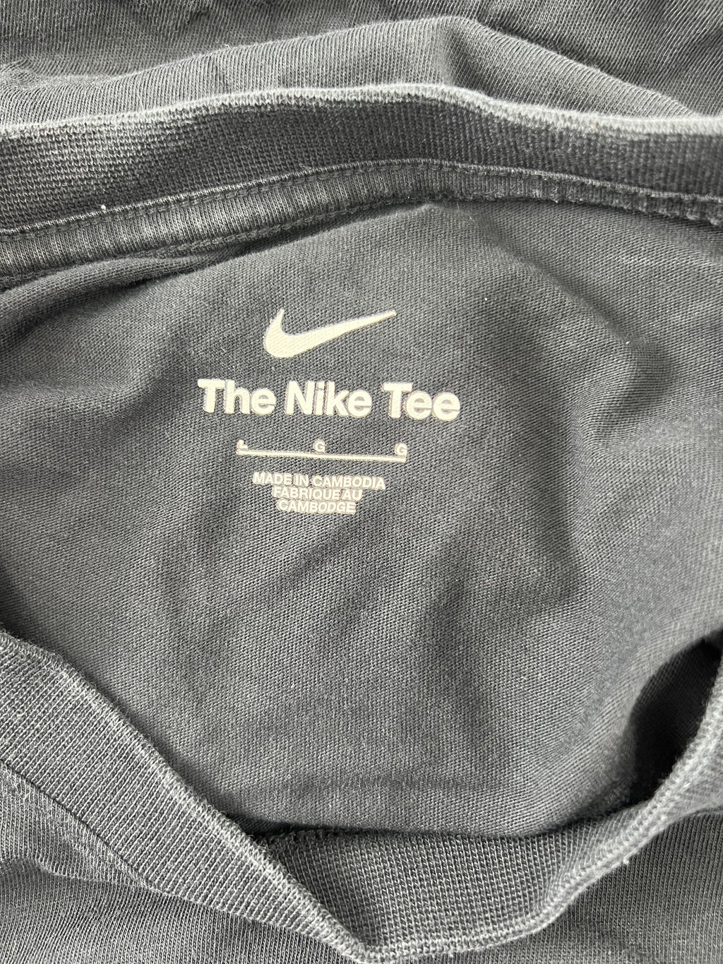 Inside neck label of Liverpool FC Nike T-shirt showing 'The Nike Tee' and size information