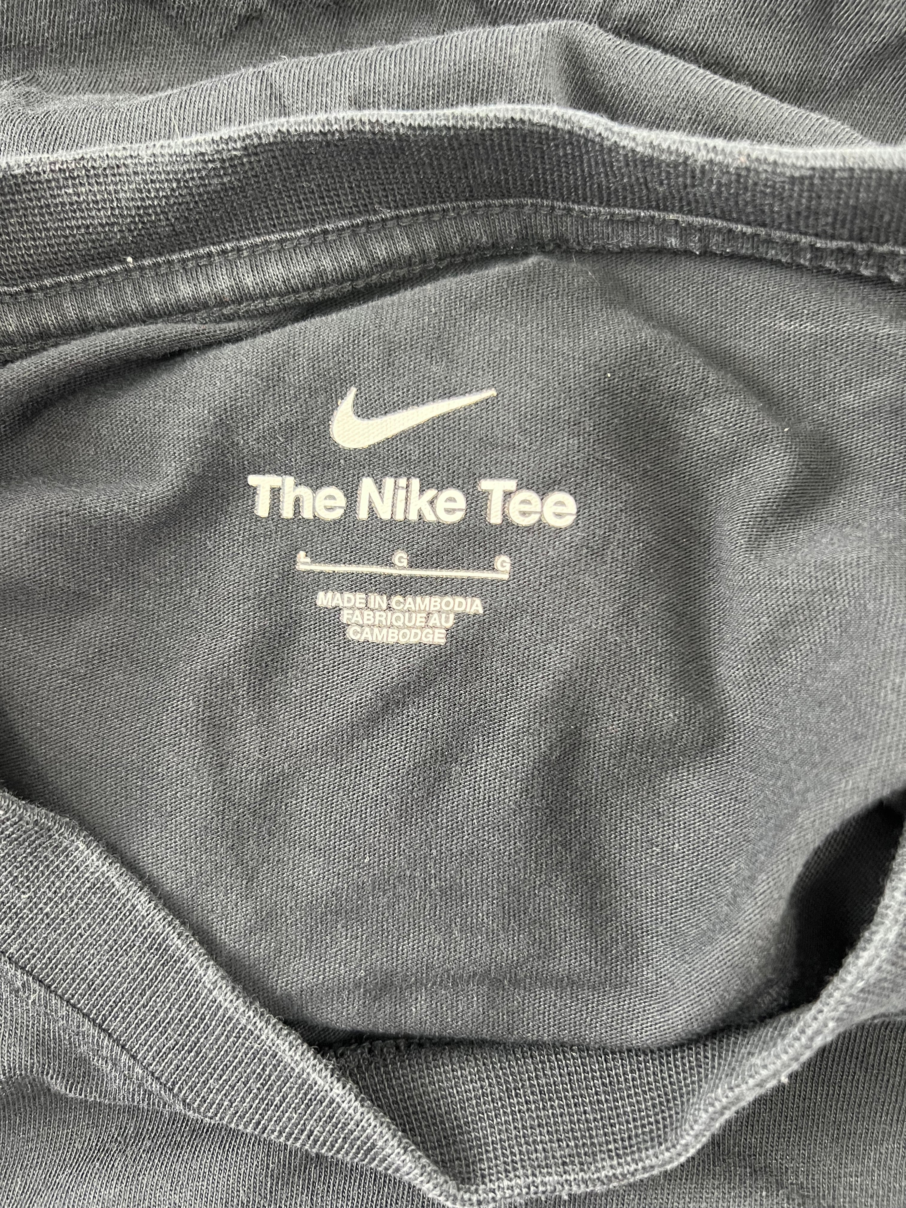 Inside neck label of Liverpool FC Nike T-shirt showing 'The Nike Tee' and size information